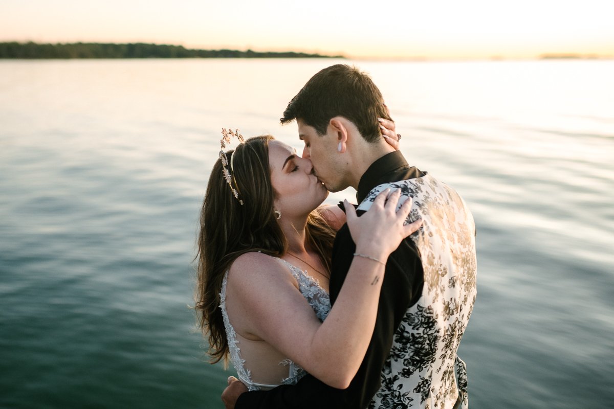 Bride and groom kissing near sea