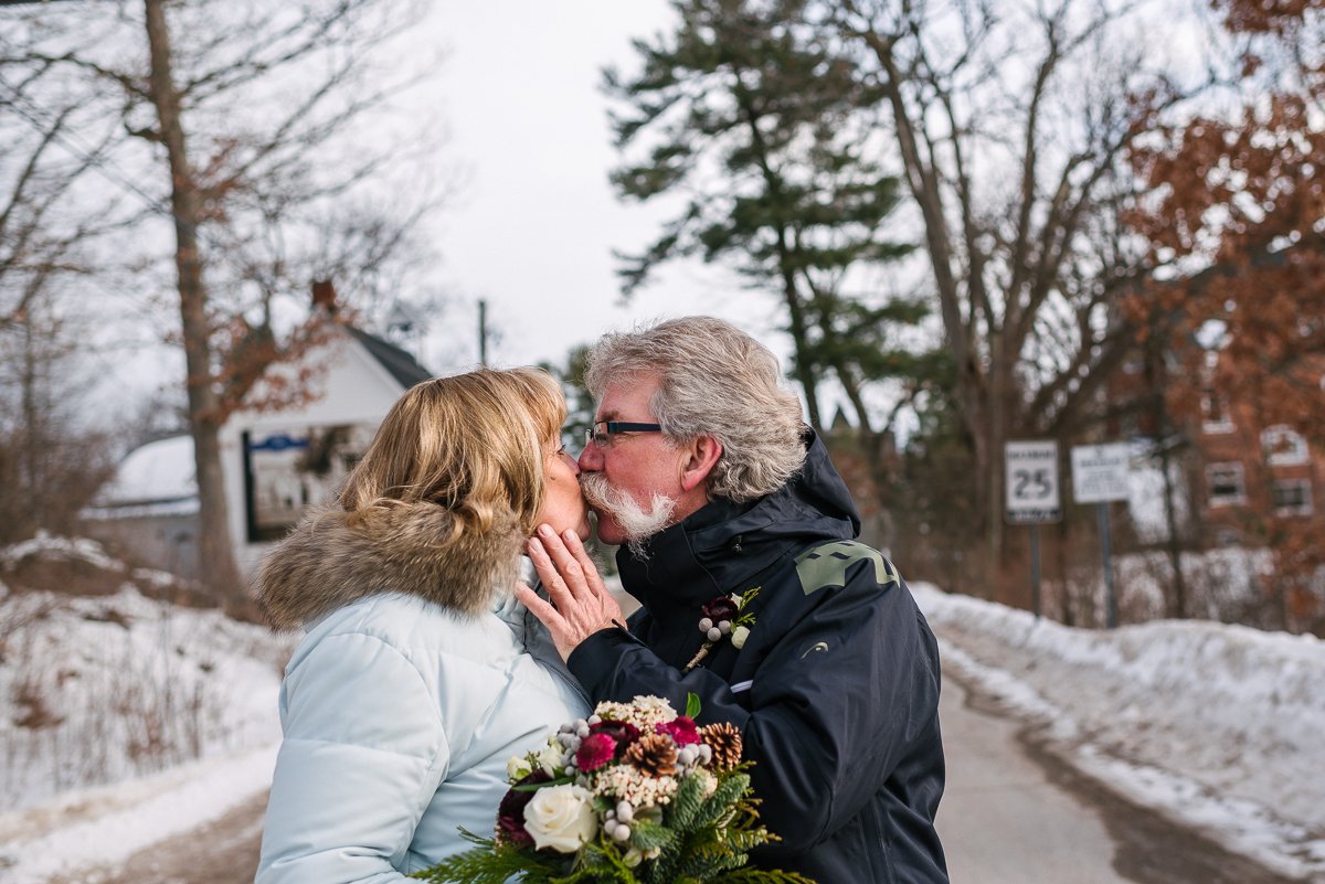 Bride and groom kissing in the snowy street
