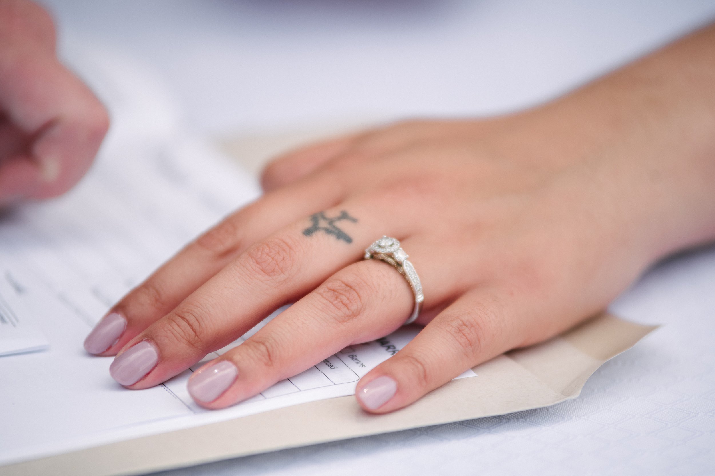 Closeup of hands of a woman signing marriage papers