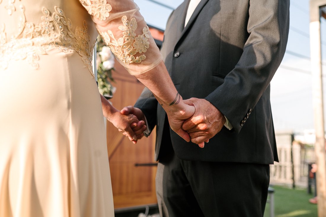 Couple holding hands in the wedding ceremony.