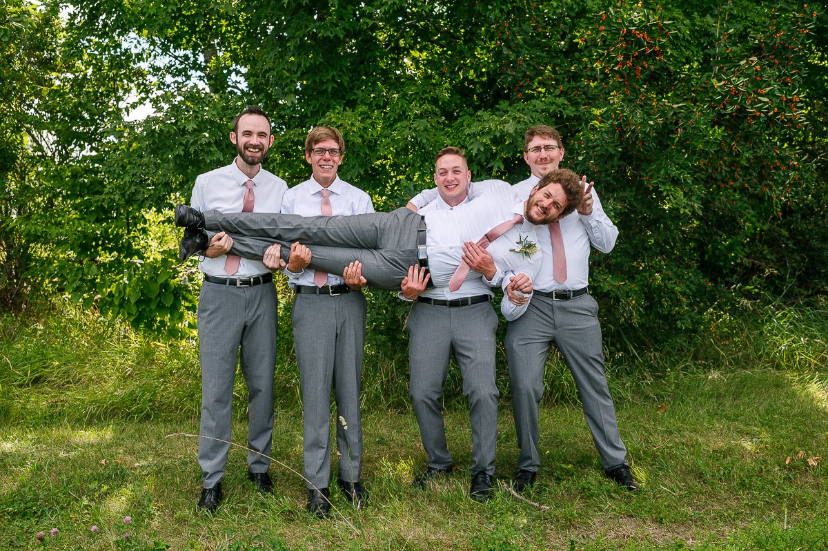 Groom and grooms men in white and grey outfit.
