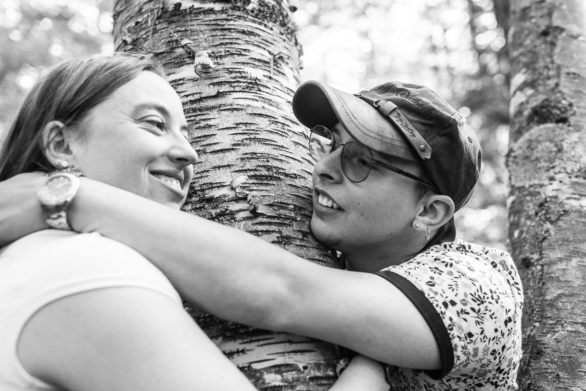 Black and white picture of couple hugging the tree