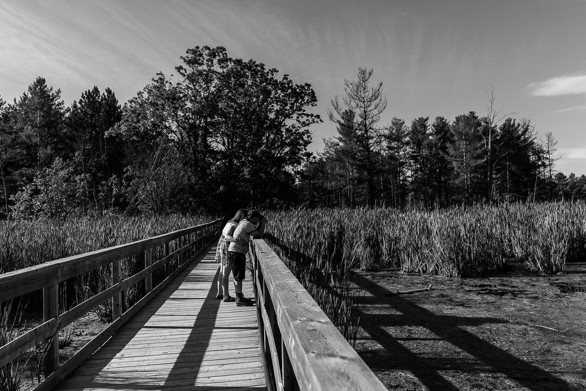 Black and white picture of couple looking down at the water.