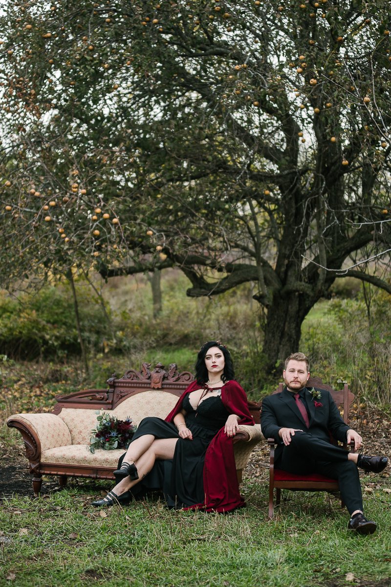 Bride and groom sitting on couch after the halloween themed wedding ceremony