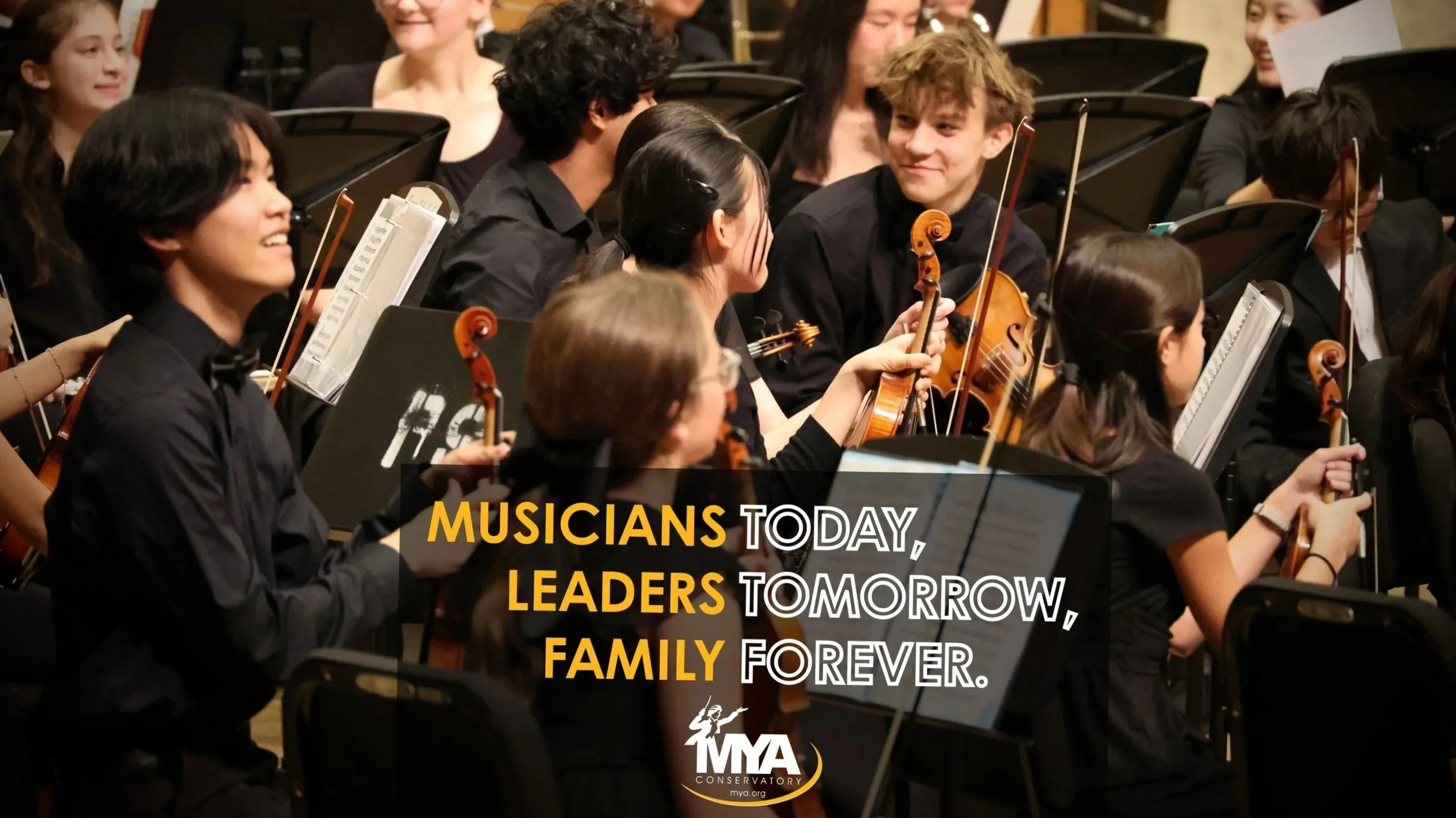 A group of young musicians, primarily violinists, dressed in black, sitting on a stage with music stands, smiling and interacting. Overlaid text reads: 'Musicians today, leaders tomorrow, family forever.'