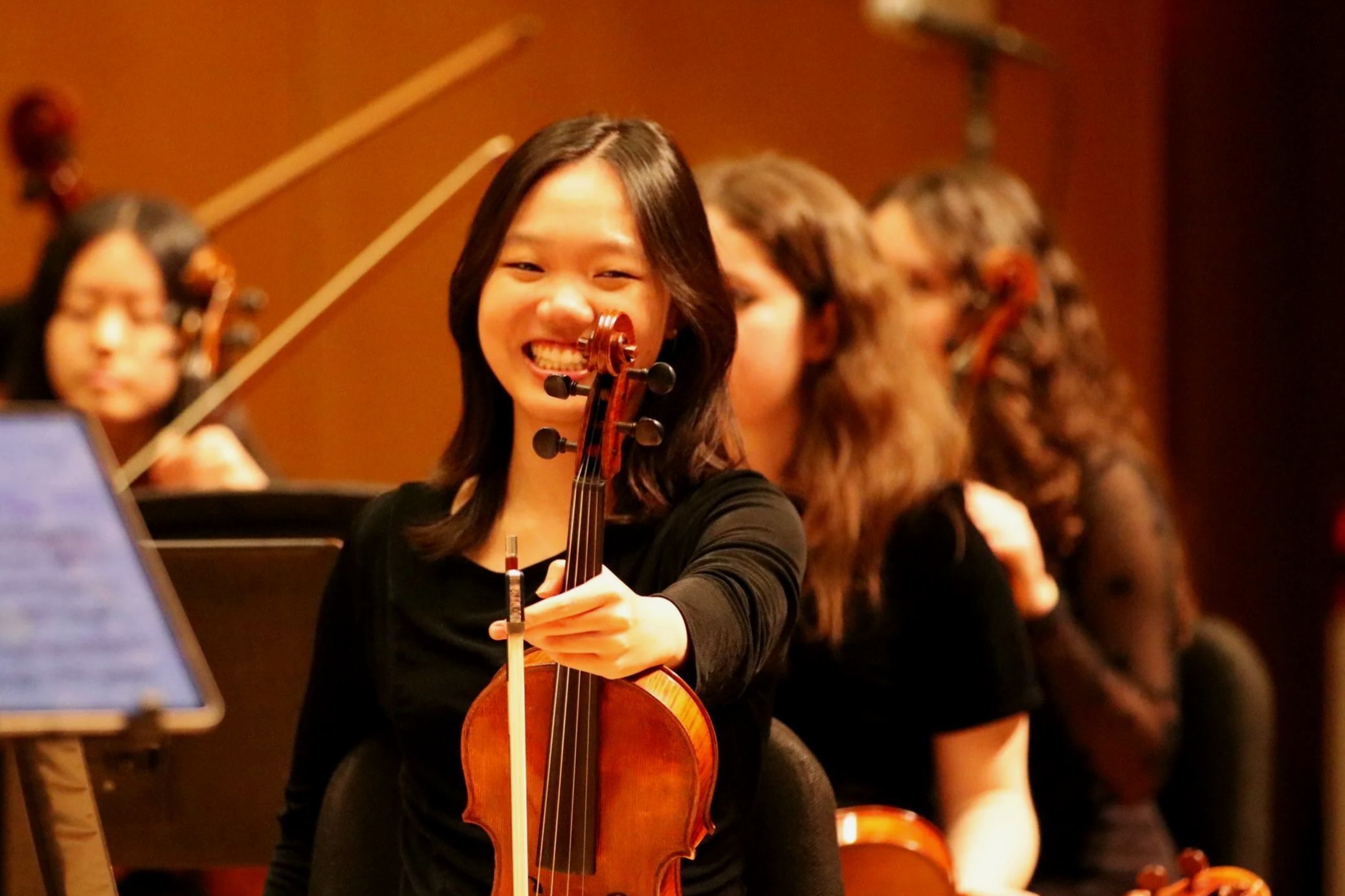 teenage violist smiling and holding her viola