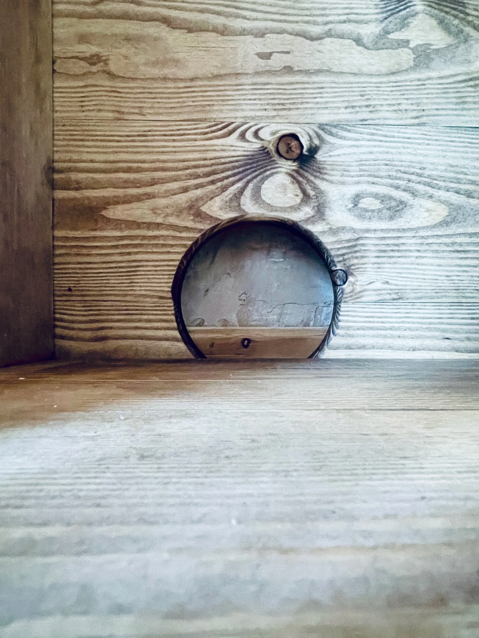 Detail of circular rear cable port inside solid wood TV unit for concealed wiring