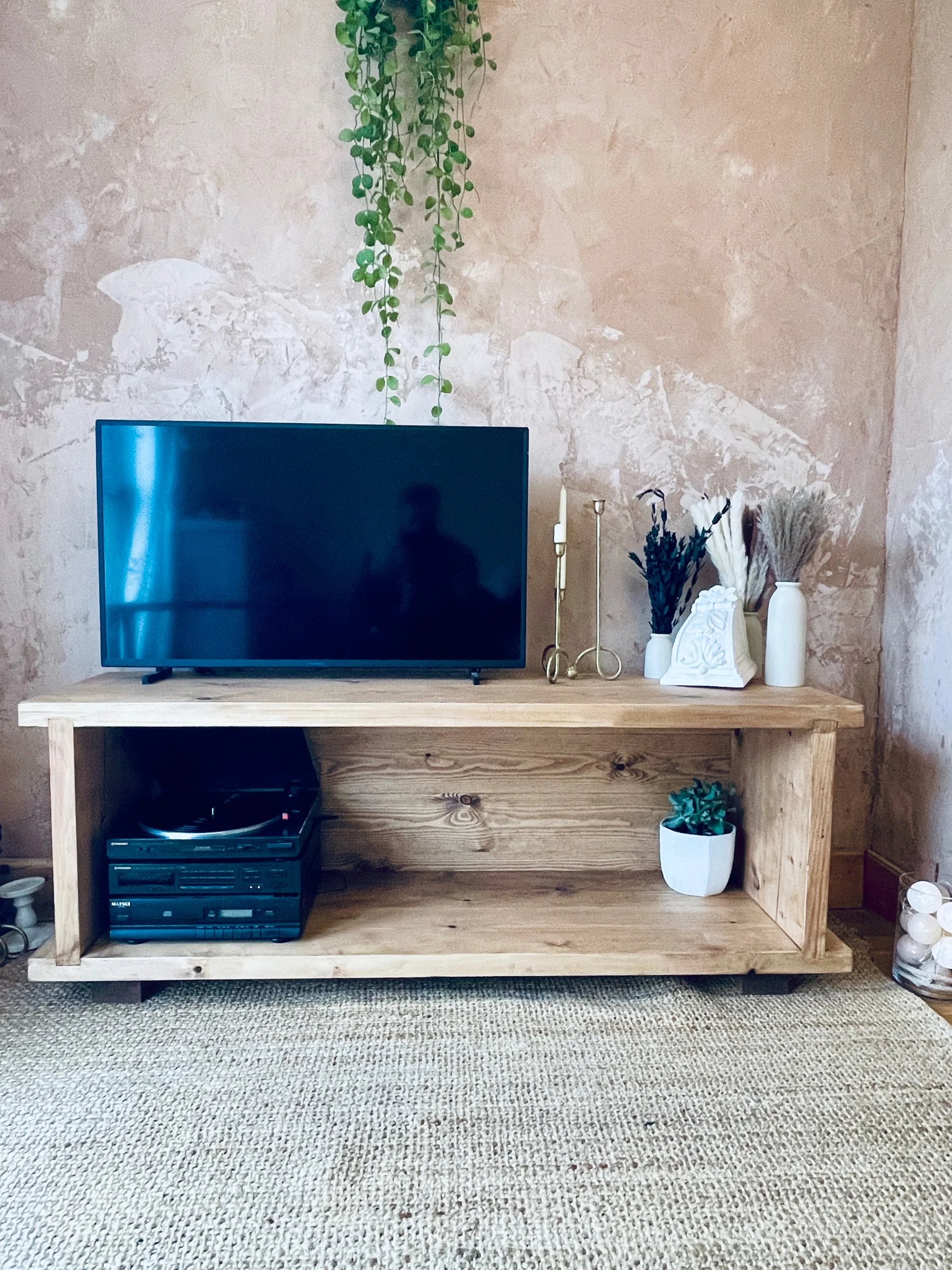 Handmade solid wood low TV stand with full back panel and open storage shelf, shown with television on top