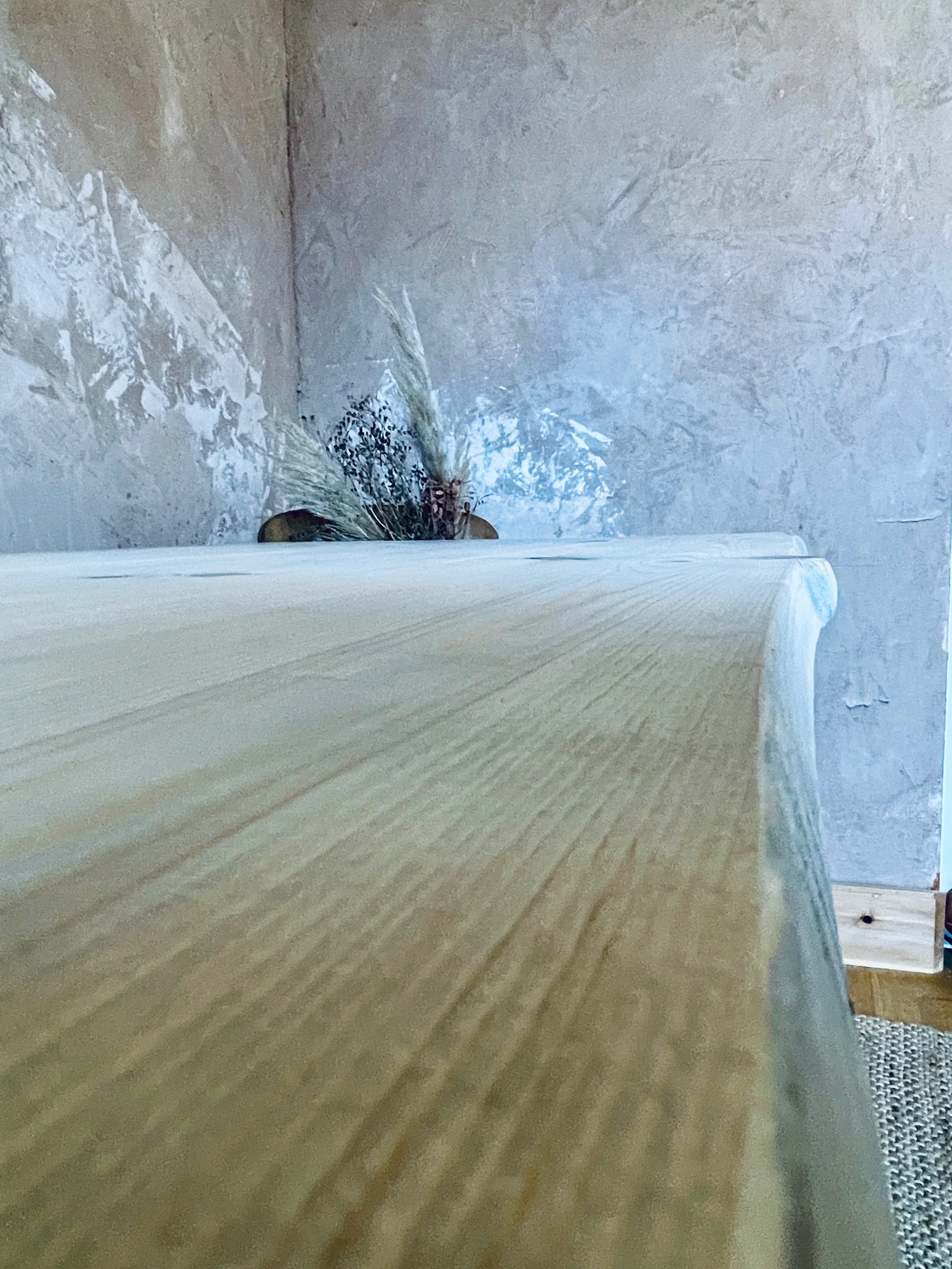 Corner angle of solid-wood dining table showing smooth edges and pale finish