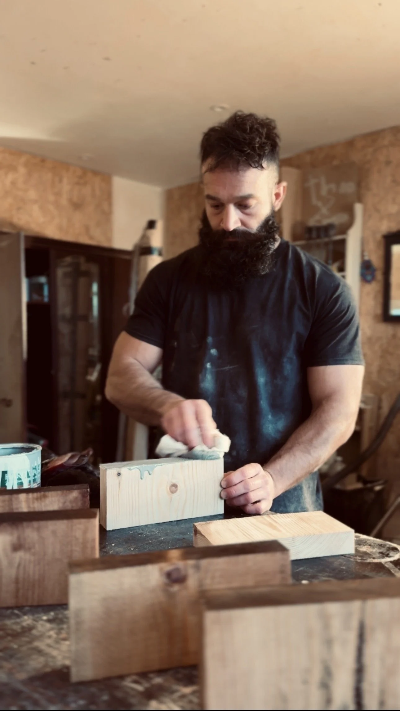 Hand applying wood finish to solid wood samples in the Artemis London workshop, revealing natural grain and tone.