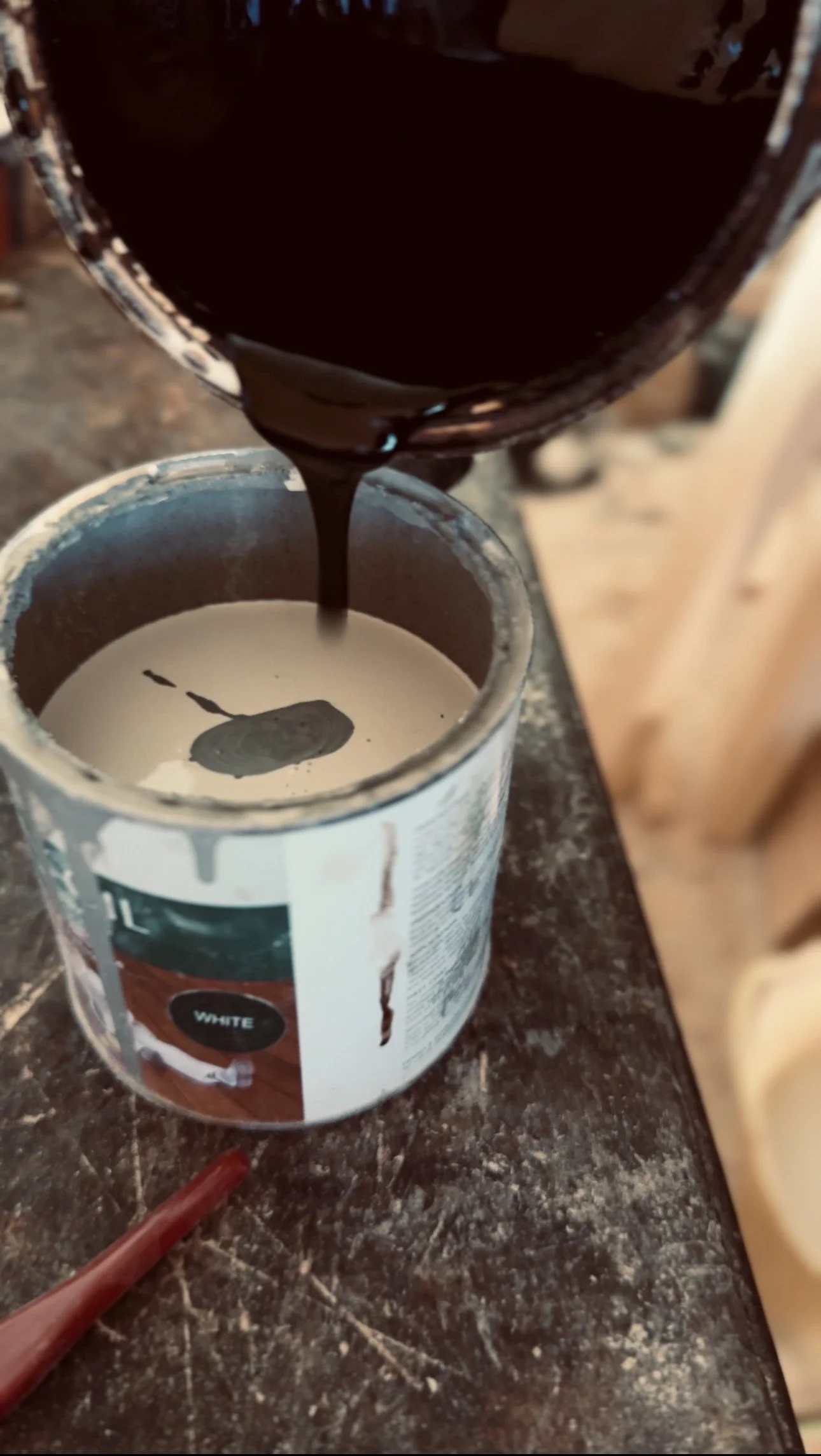 Preparing custom wood finish by hand in the Artemis London workshop before applying to solid wood furniture.
