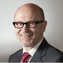 Henkilönpotrettikuva, mies hiukseton, silmälasit, puku ja solmio, hymyilevä