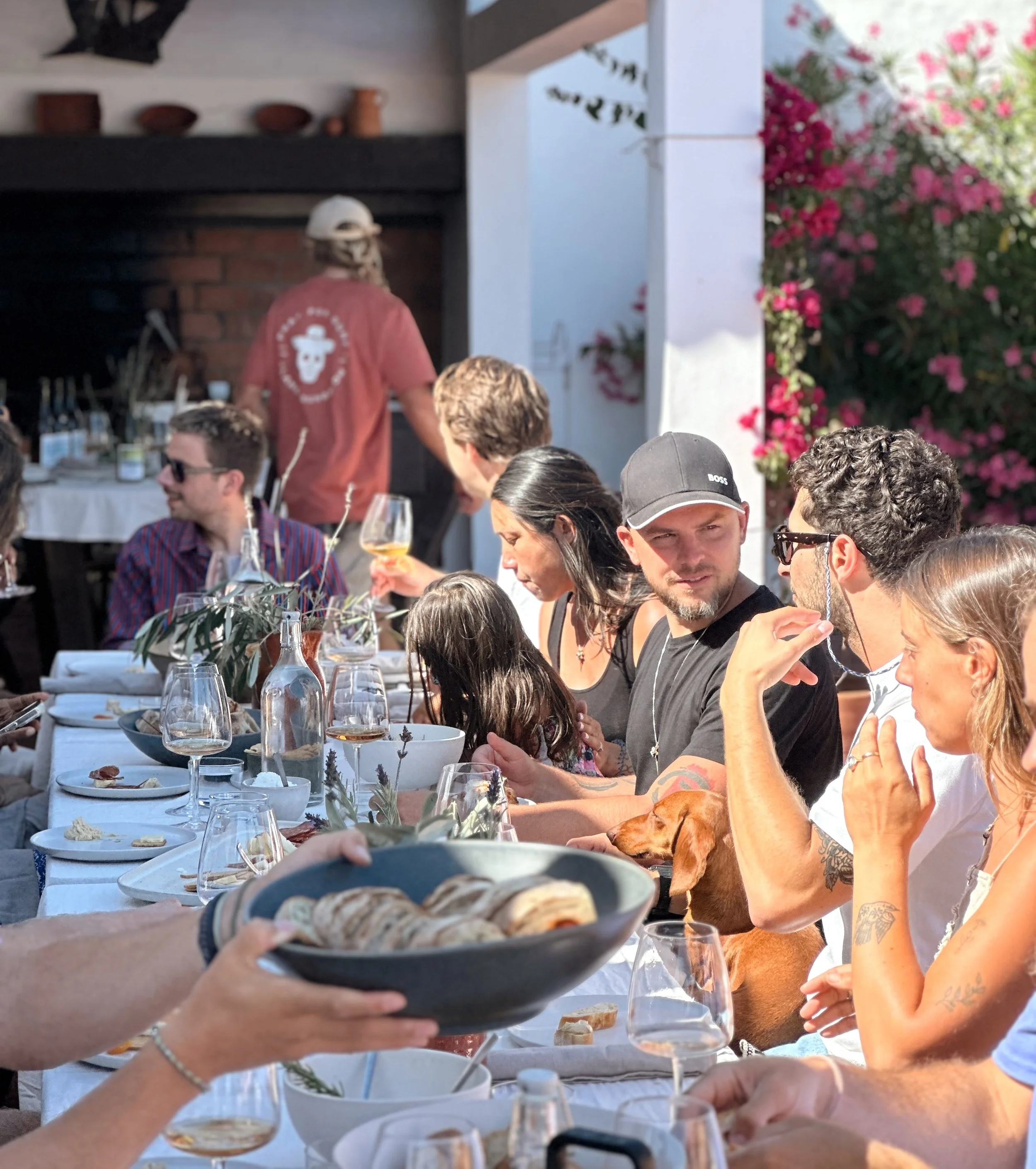 Friends and family sharing a long-table dinner at golden hour at Blanco Bungalow, a group villa near Ericeira, Portugal
