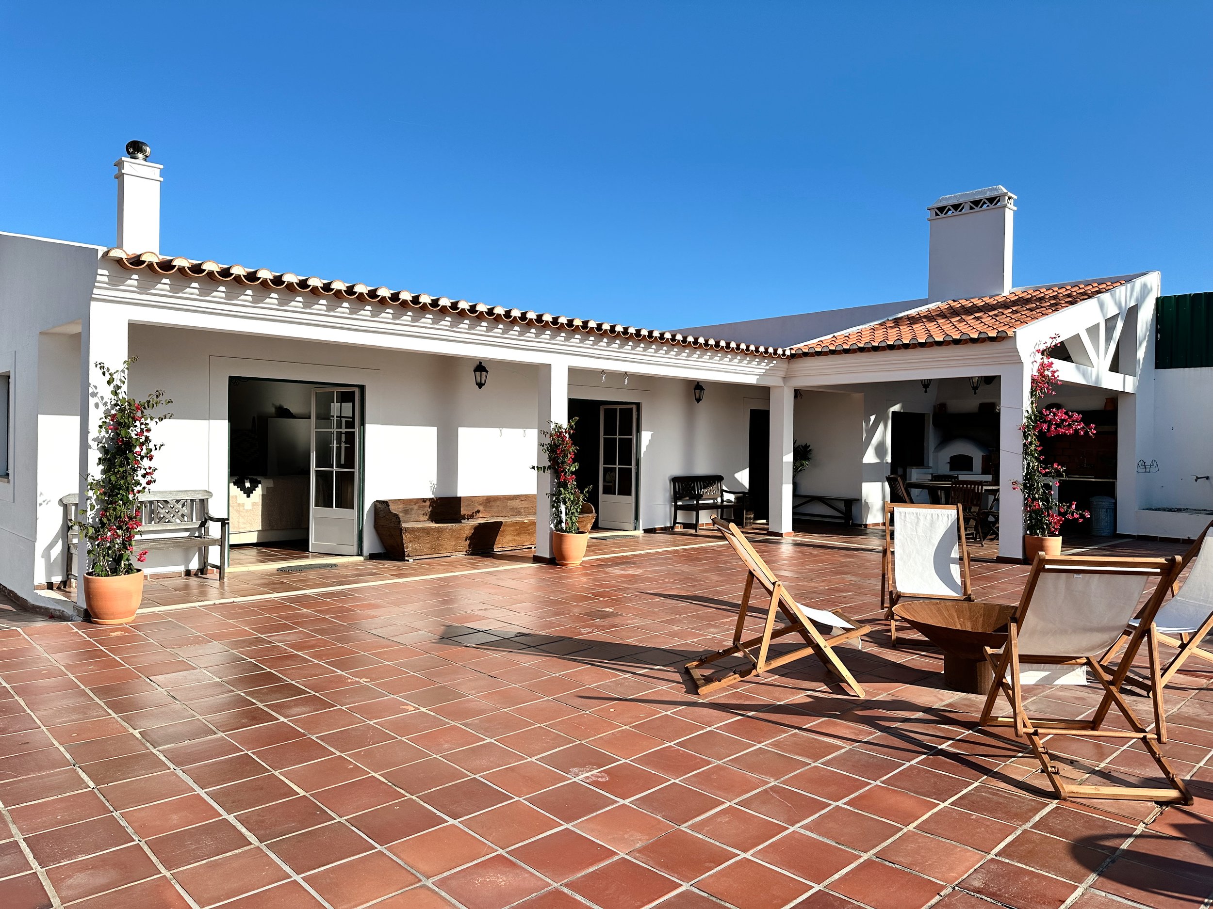 Sunny terracotta courtyard at The Blanco Bungalow ranch, Ericeira