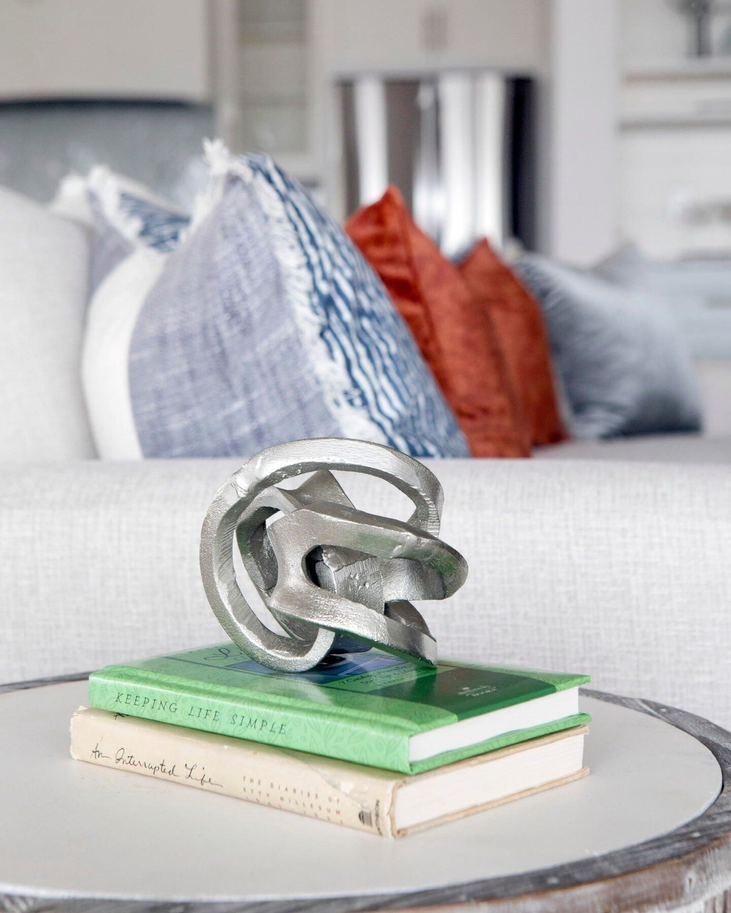 There so many options for coffee table decor. This polished chrome structure adds a really unique look to this side table. It&rsquo;s not too much to take away from the colorful pillows on the couch, it blends in perfectly! Shop similar items on my L