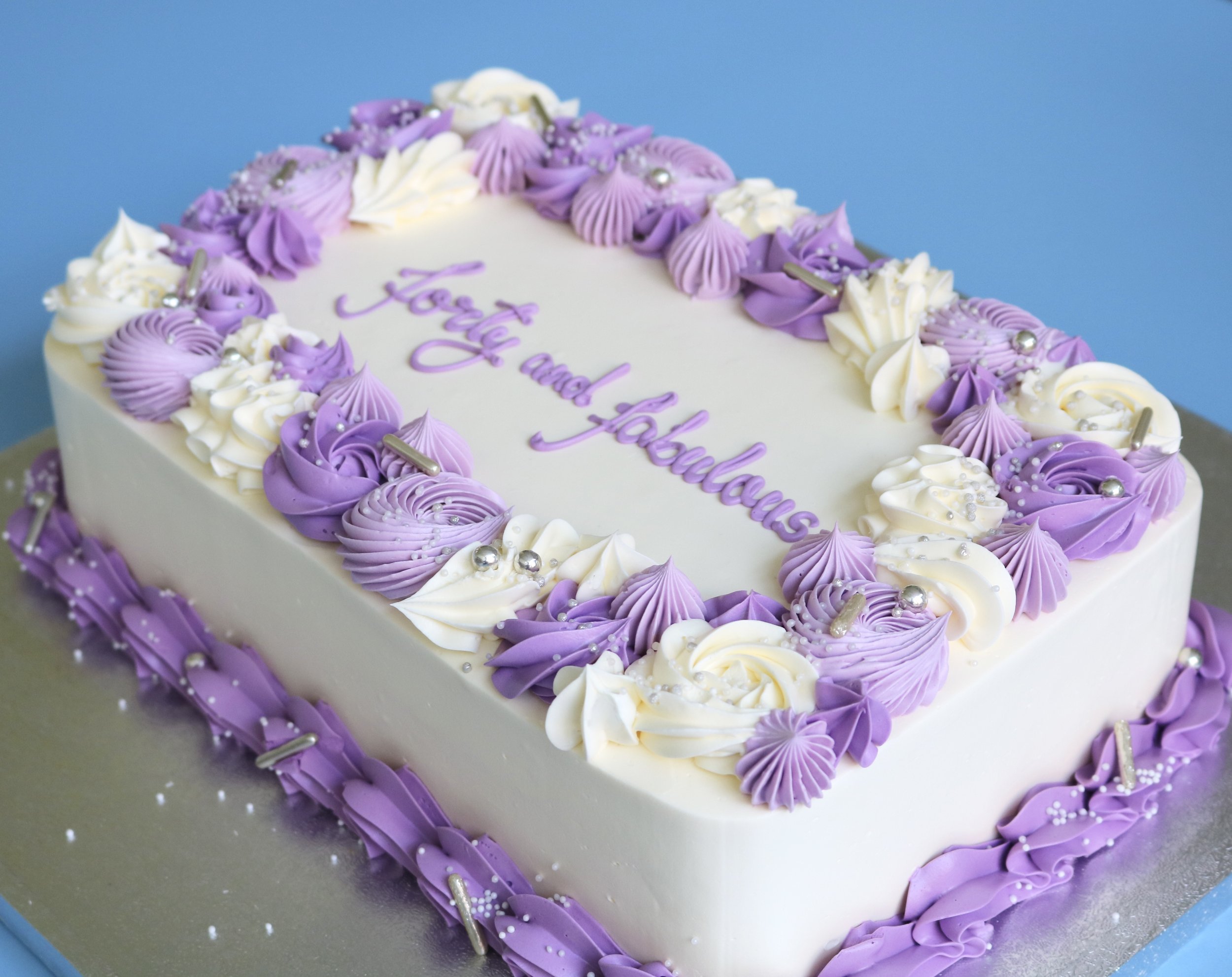 sheet birthday cake in cream cover and lilac swirly piping