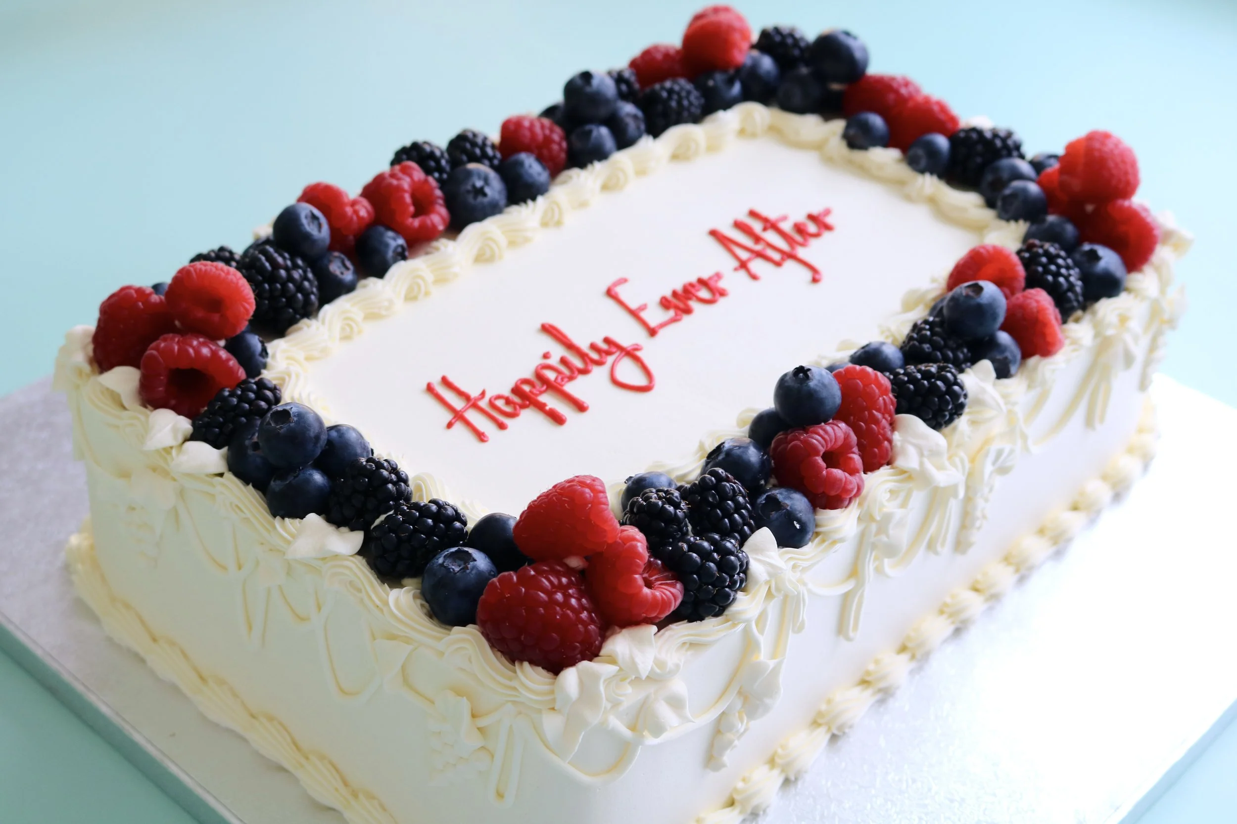 Vintage sheet wedding cake with cream buttercream piping, delicate side details and fresh berries