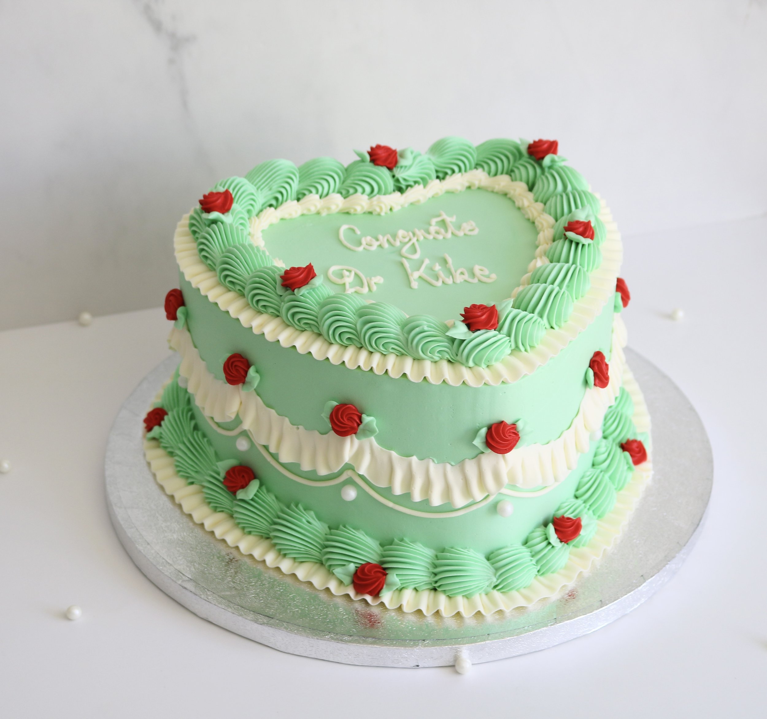 vintage wedding cake in heart shape, decorated in white and pistachio green colour theme