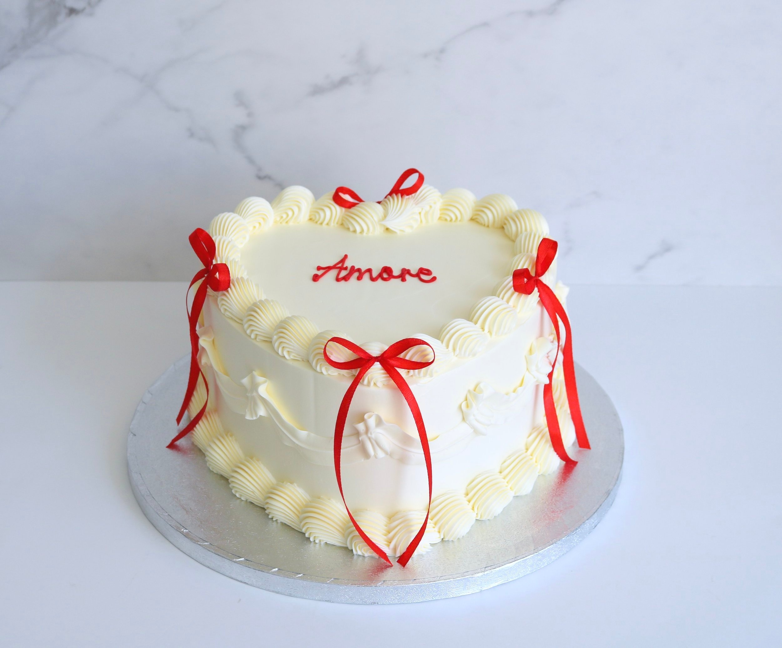 wedding cake with vintage piping and red ribbons