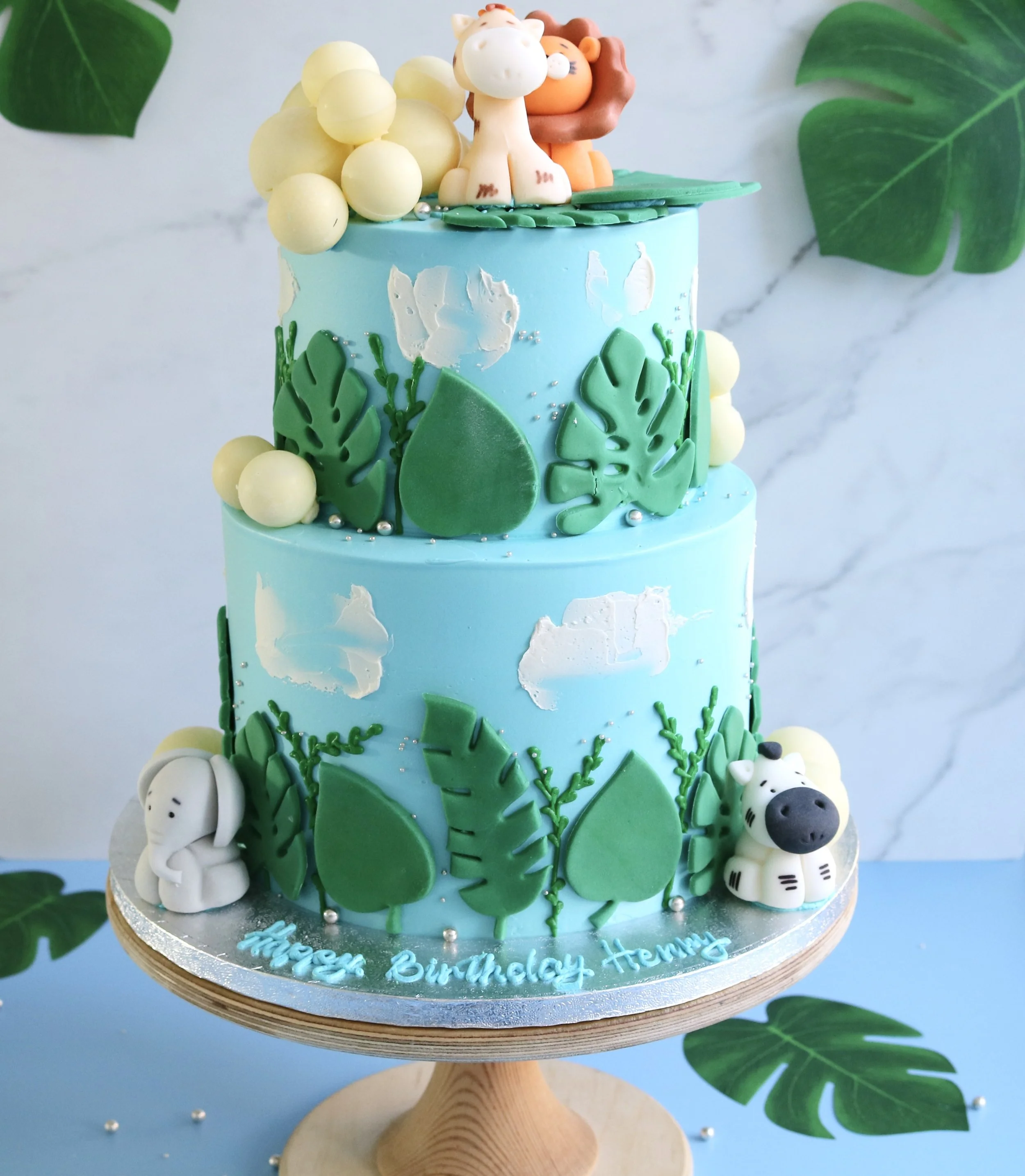 2 tiered animal cake for children in London with edible animal toppers and balloons
