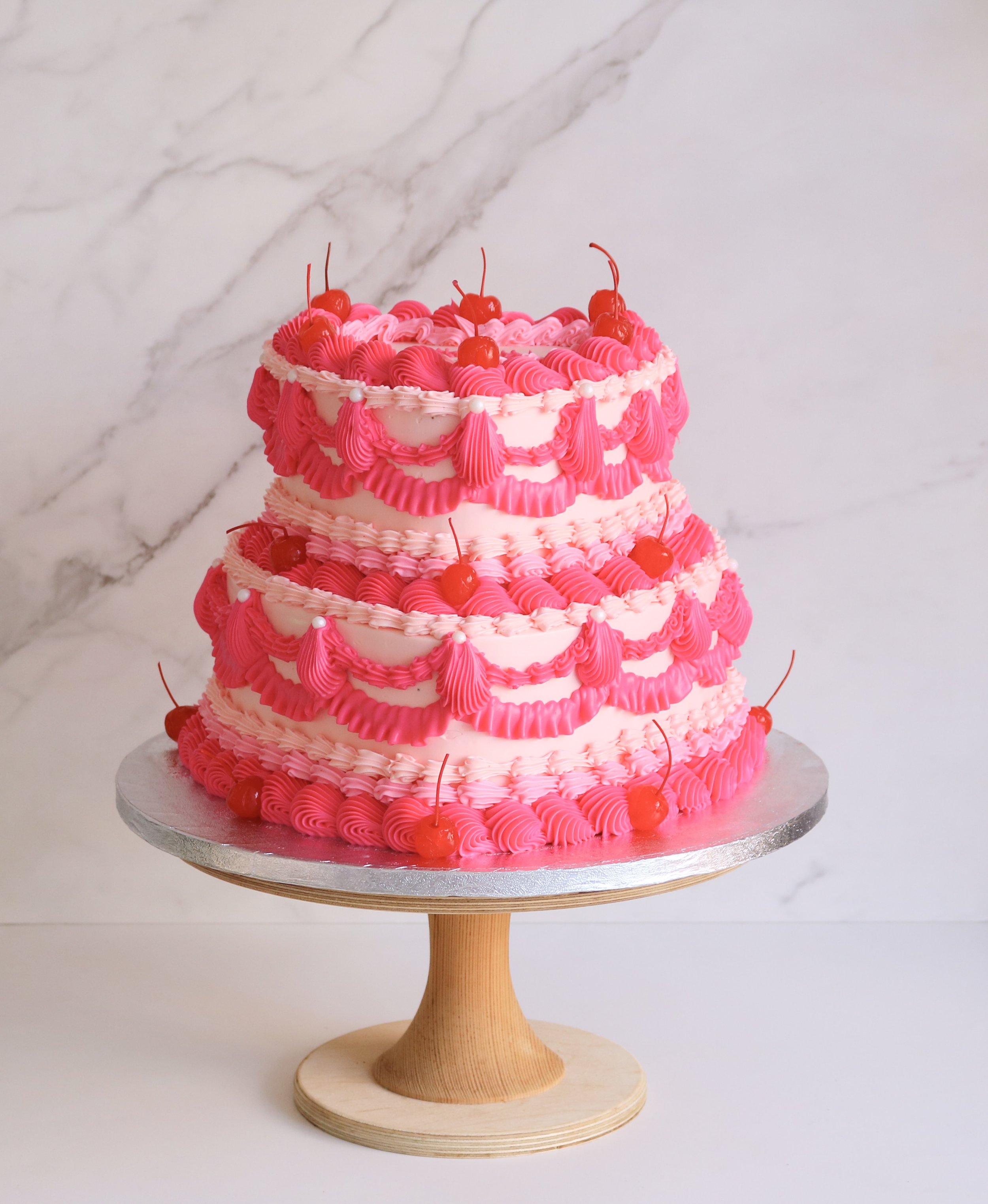 2 tiered heart-shaped cakes in hot pink colour theme, with vintage decorations for all occasions in London
