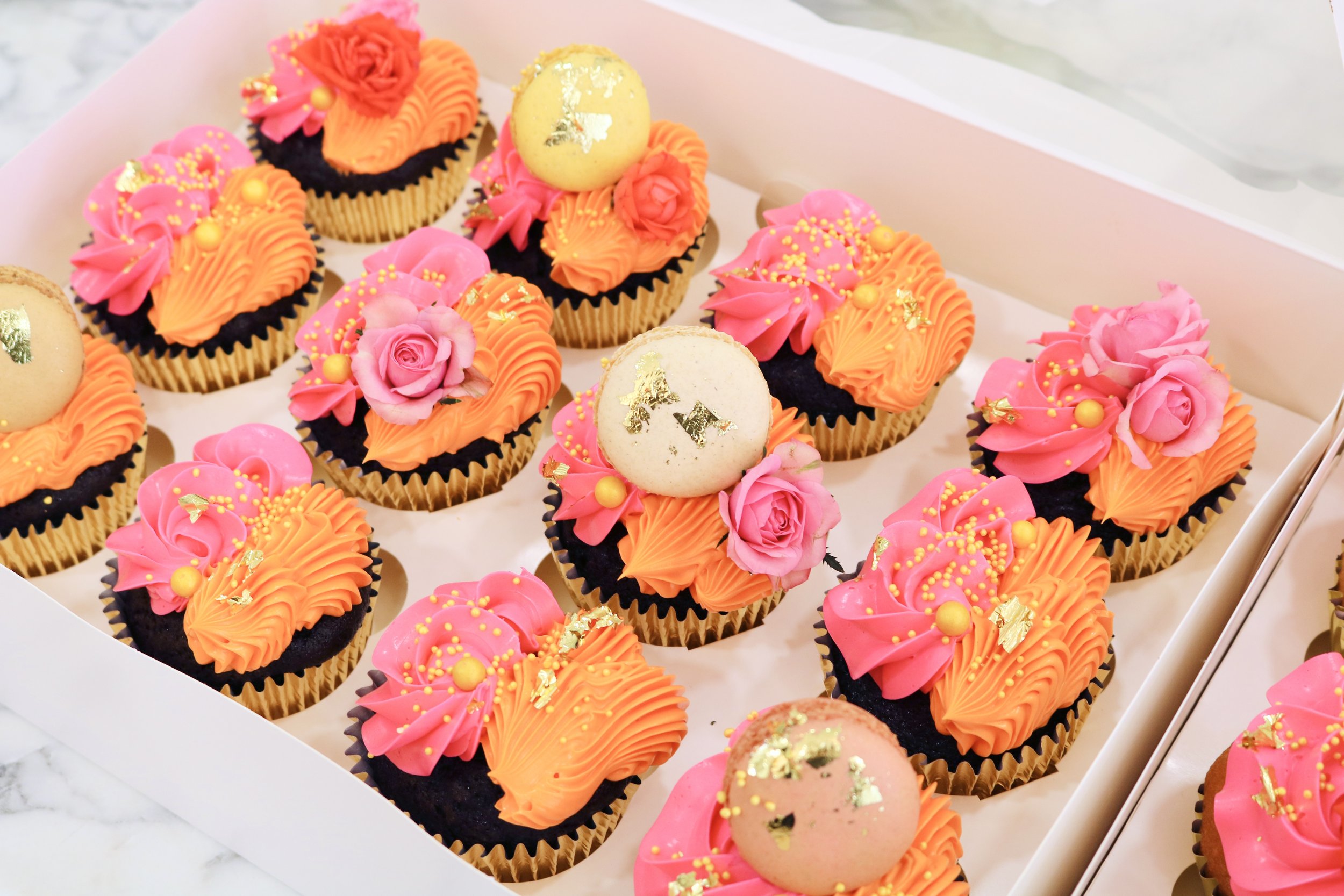 bright coloured cupcakes with macarons and gold leaves