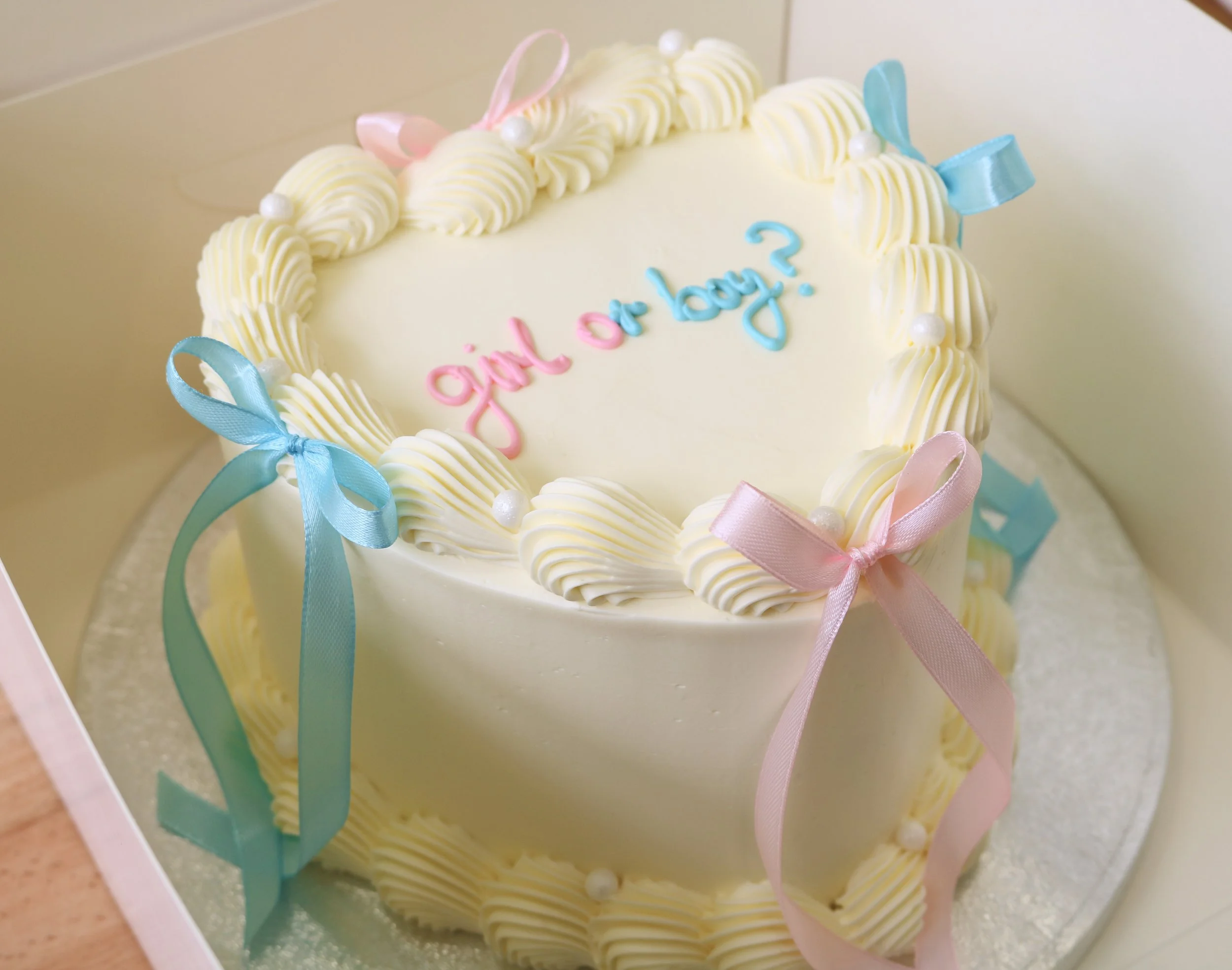 Heart shaped gender reveal cake with pink and blue ribbons and vintage buttercream piping in London. (Copy)