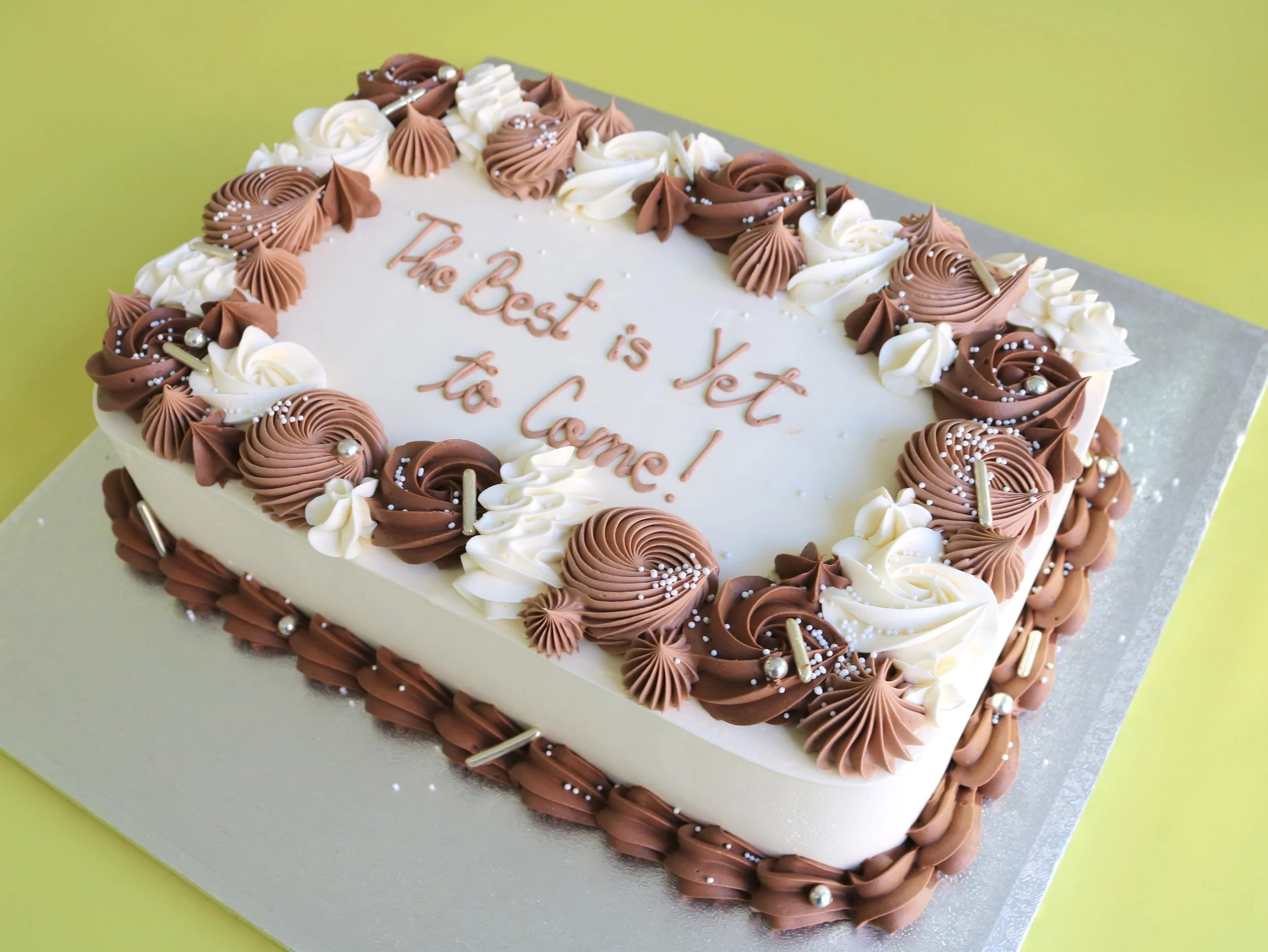 Elegant rectangular sheet cake with custom colours, hand-piped buttercream borders, swirls, pearls, and sprinkles, ideal for corporate events and office catering.