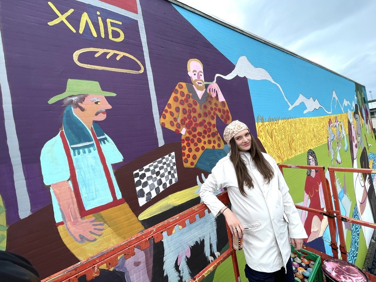 Artist next to mural work