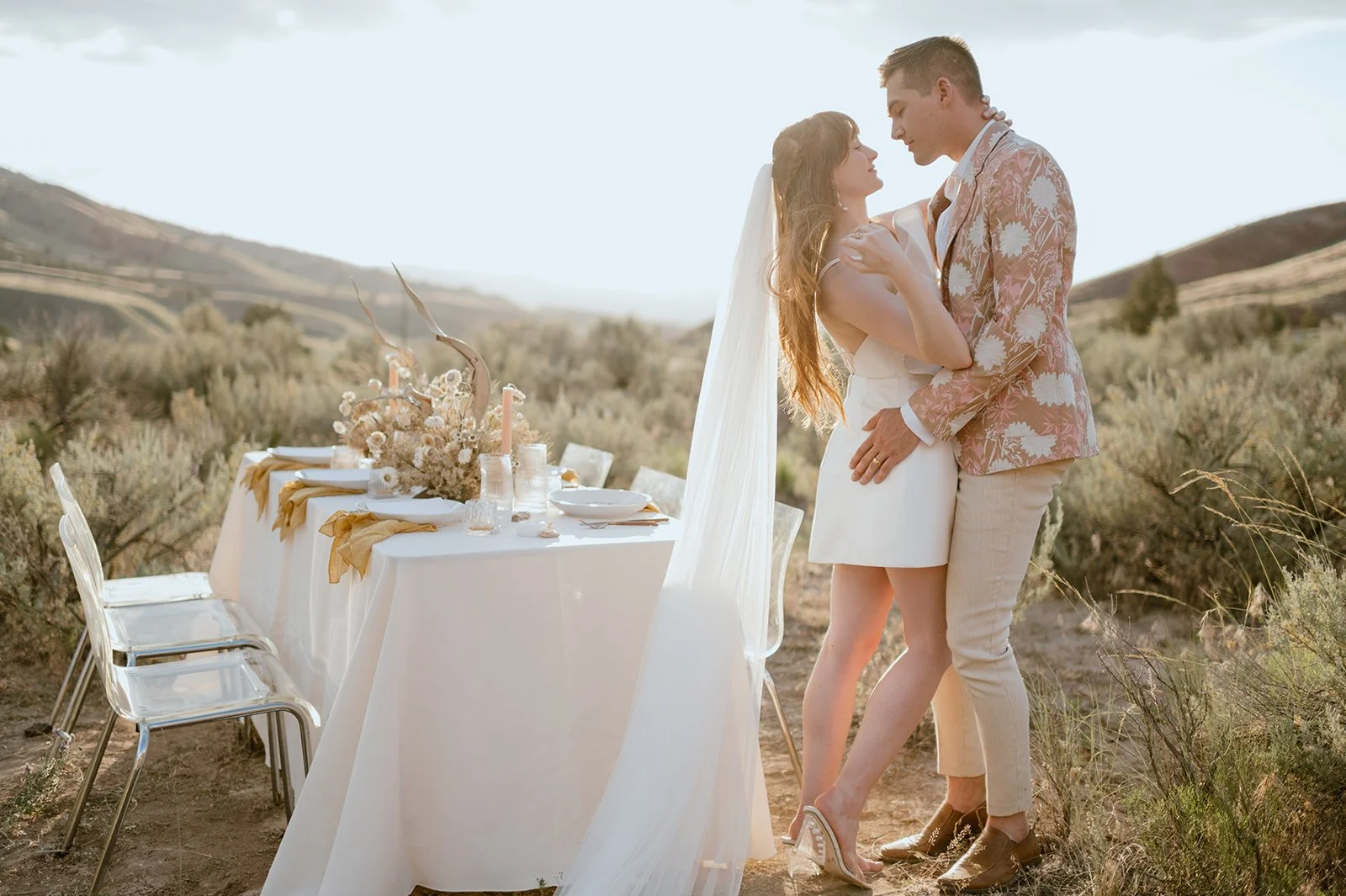 couple embracing in front of their sweetheart table during their elopement at the Painted Hills in Oregon