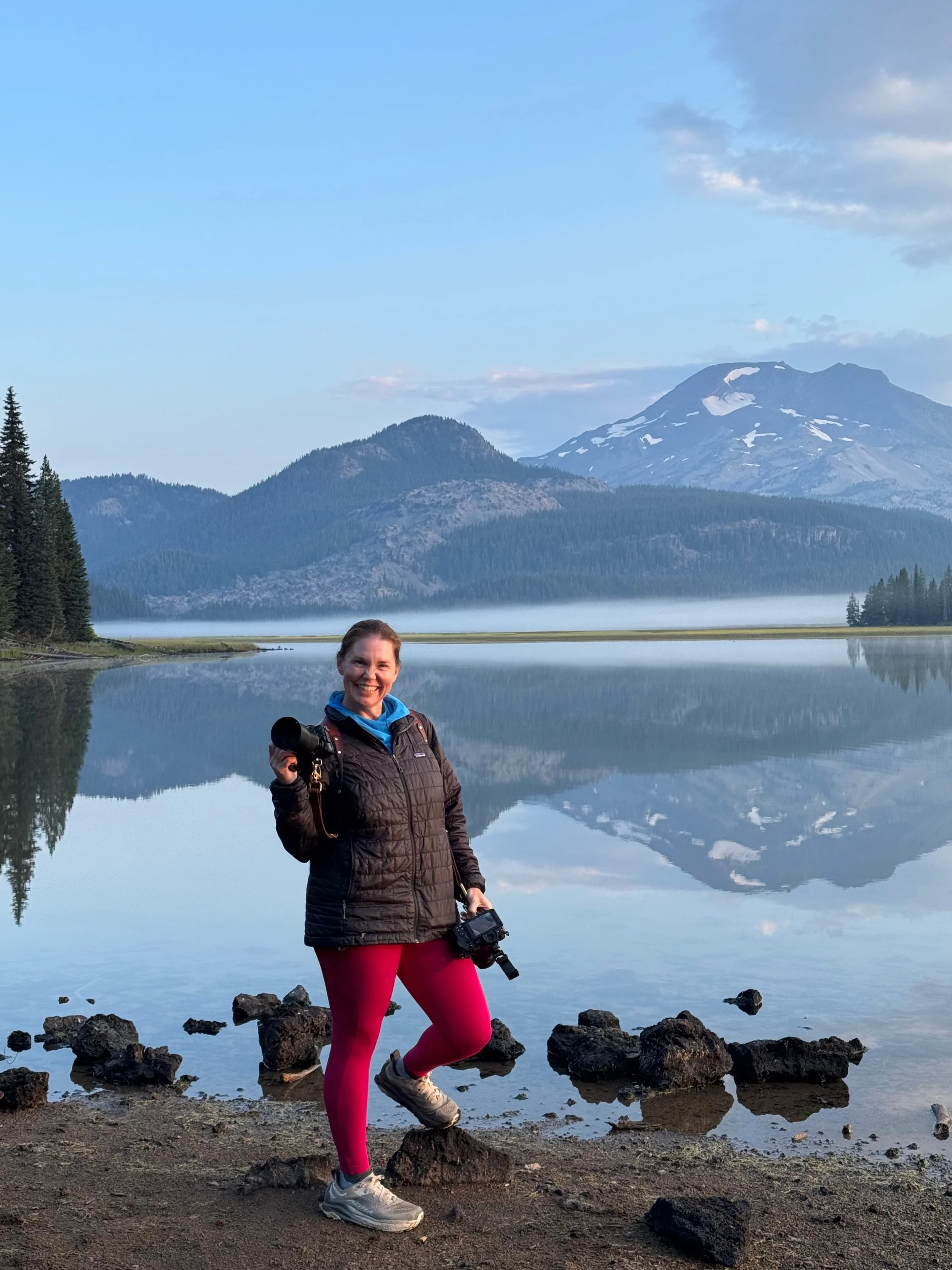 photographer holding camera at sparks lake at sunrise