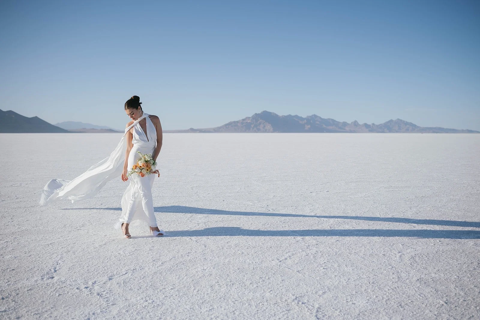 Bride with a flowy gown and scarf on the Salt Flats in Utah