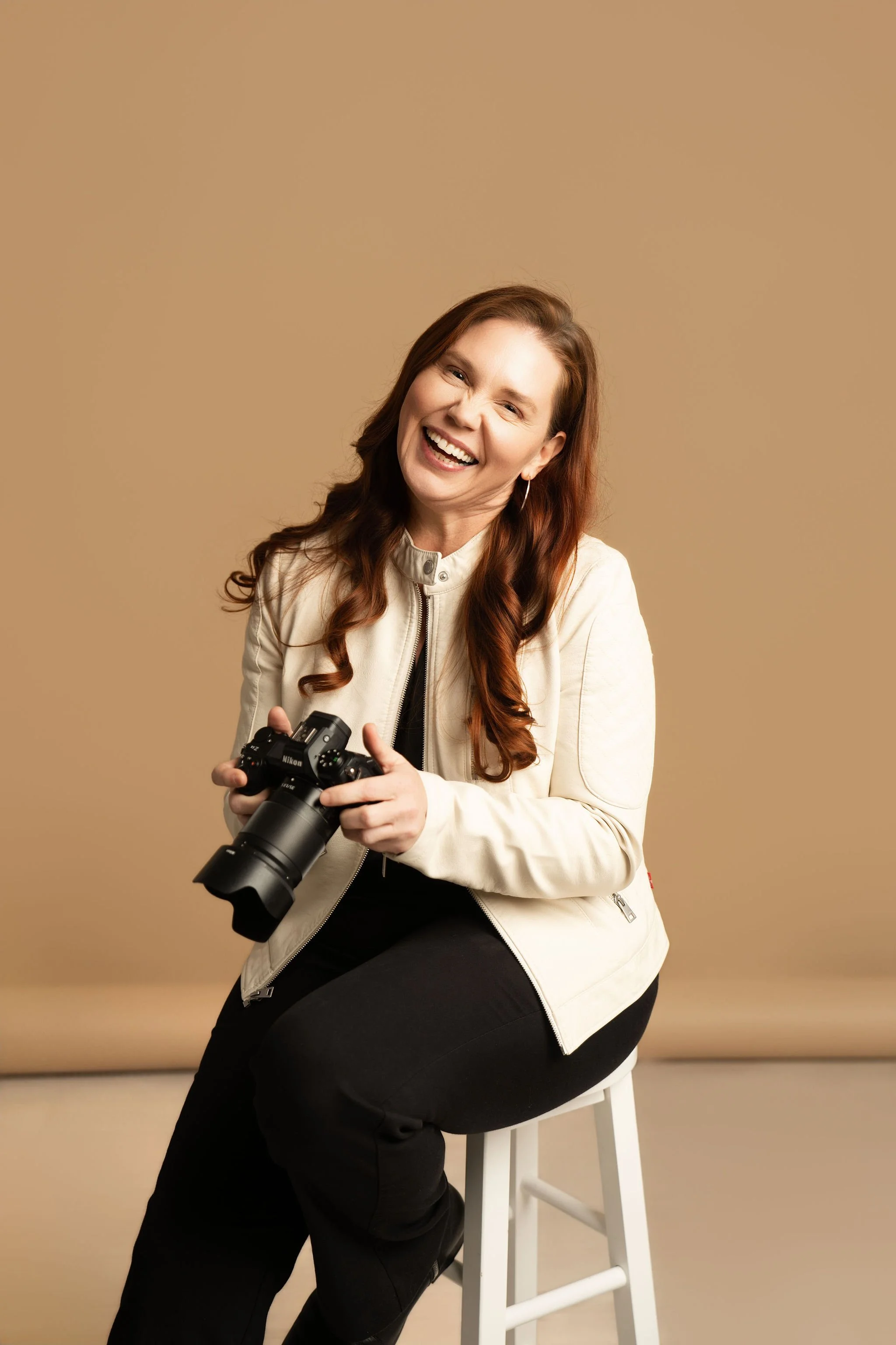 photographer holding her camera in a studio