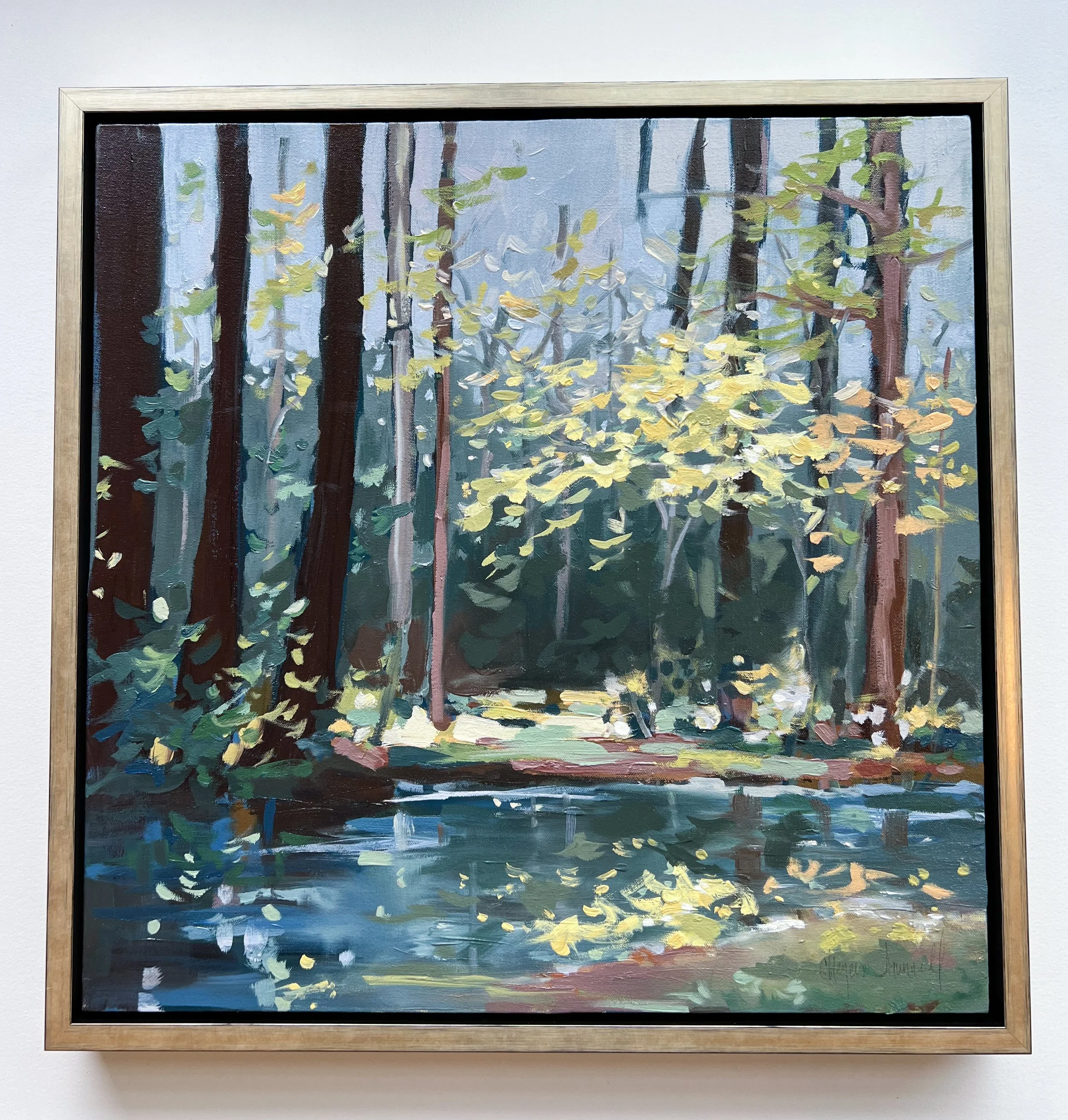 Original oil landscape painting by Asheville artist Cheyenne Trunnell depicting reflective water and soft light in tranquil tones through the forest, framed in champagne, 24x24 inches.