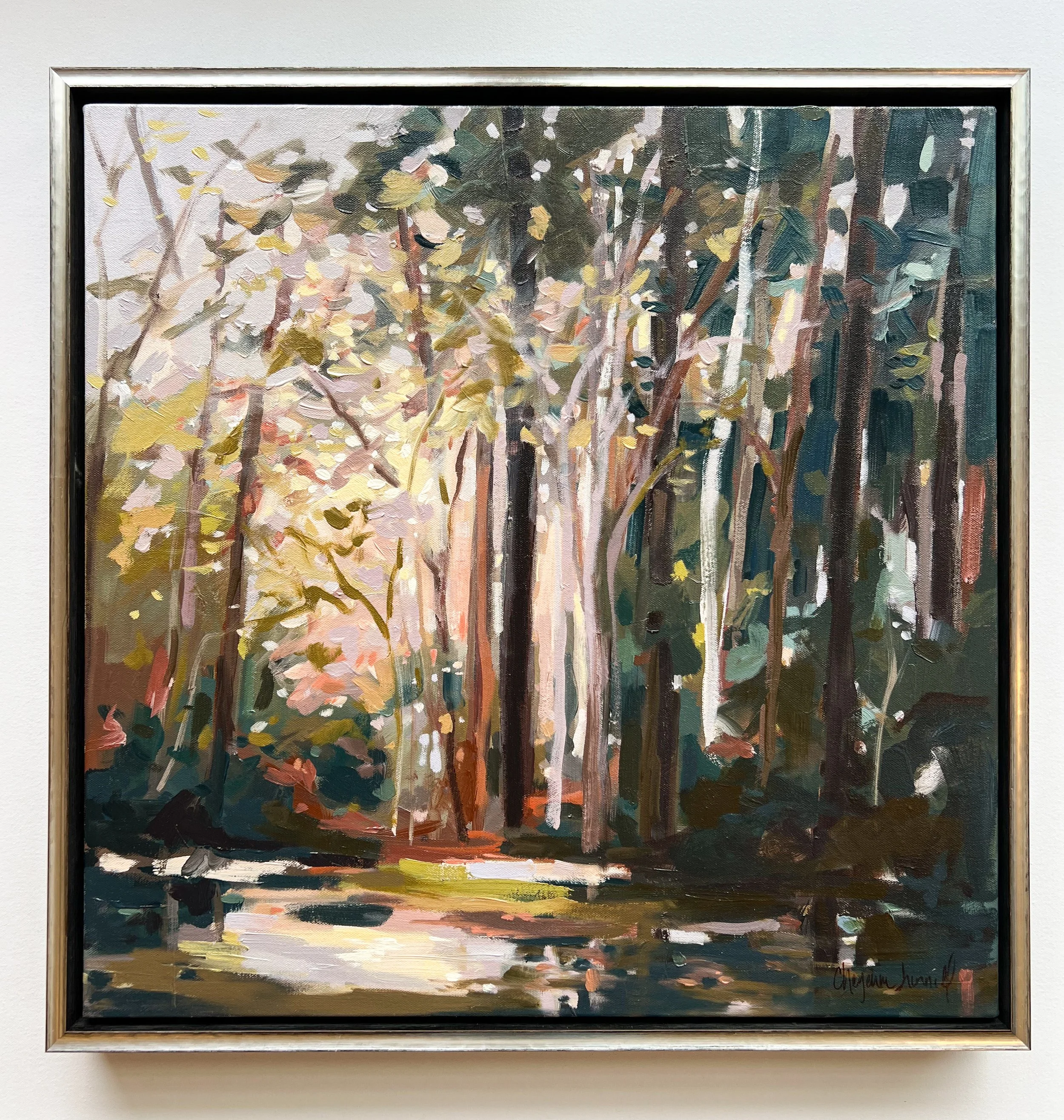 Original oil landscape painting by Asheville artist Cheyenne Trunnell depicting sunlight streaming through tall forest trees and reflecting on calm water, 24x24 inches, framed in silver.