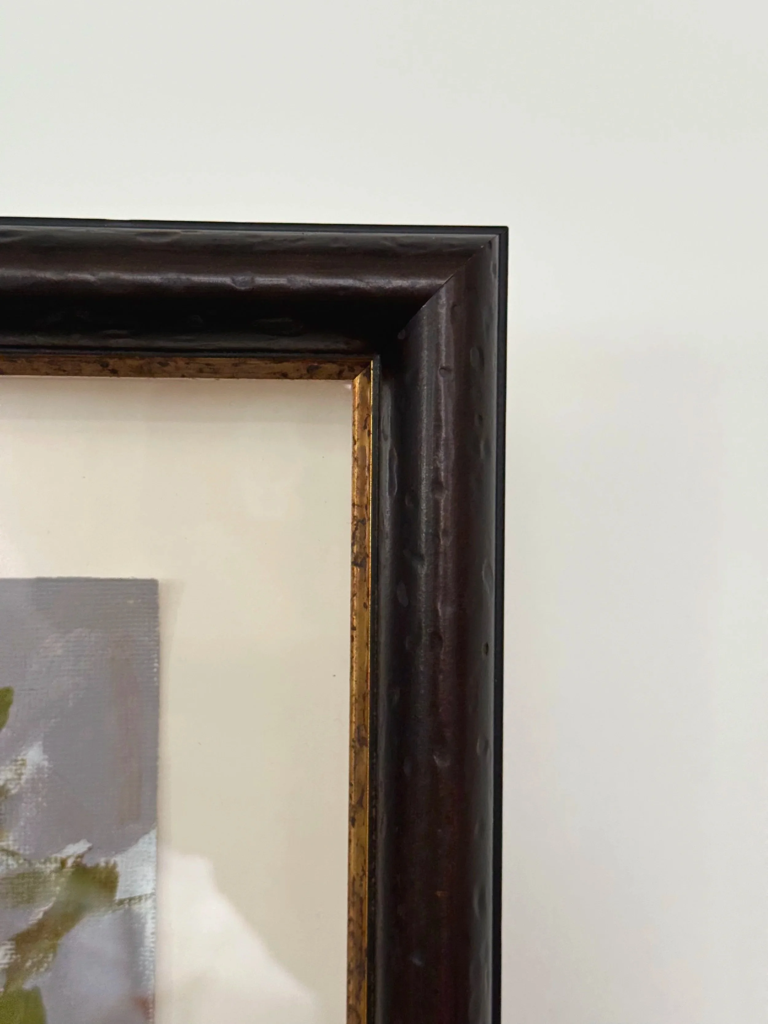 Close-up of the dark, textured frame with gold inner edge surrounding Cheyenne Trunnell’s fall landscape painting.