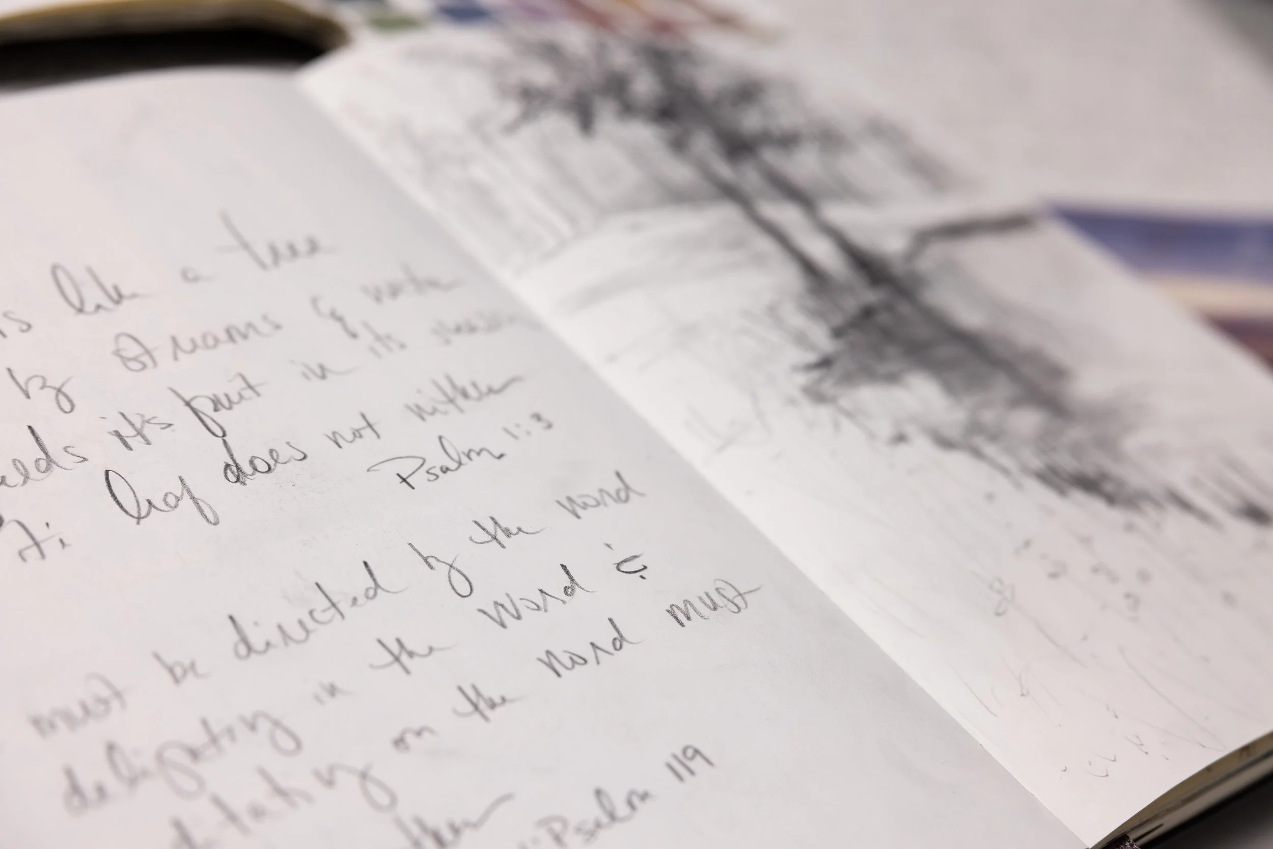 Open journal with handwritten notes about God’s Word beside a softly illustrated page.