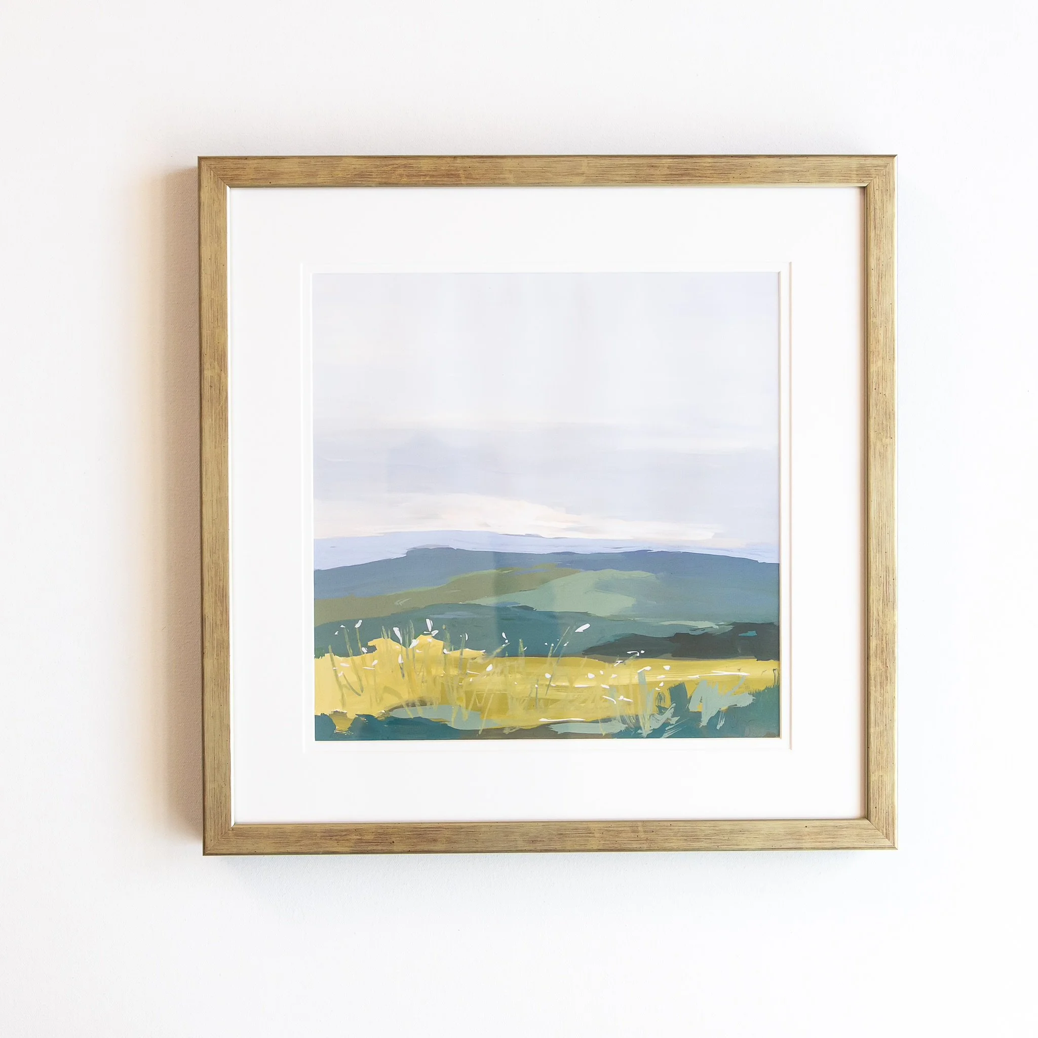 Original mixed media landscape painting by Asheville artist Cheyenne Trunnell featuring a meadow, mountains, and open sky in soft tones, framed to 17.5x17.5 inches.
