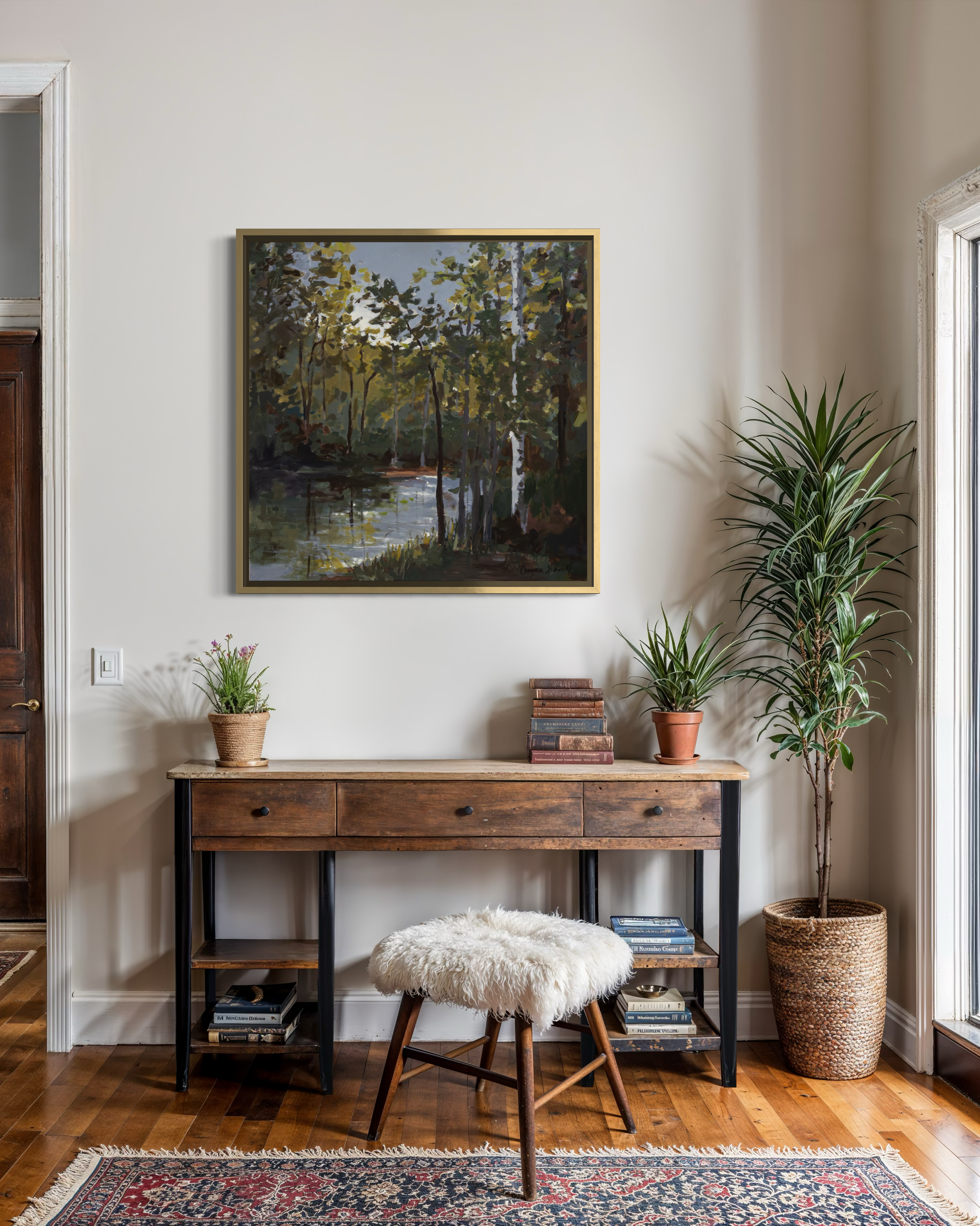 Light Upon the Water by Cheyenne Trunnell, shown framed above a wood console in a warm, light-filled interior with plants and natural textures.