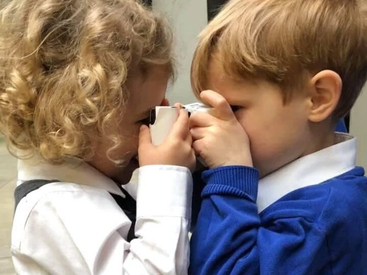 Two children taking a photo of each other