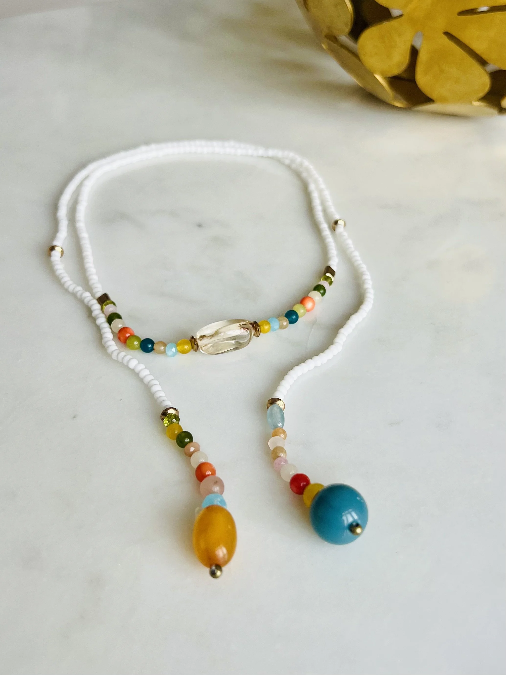 Handgefertigte Bindi Belle aus weißen Vintage-Perlen auf hellem Untergrund