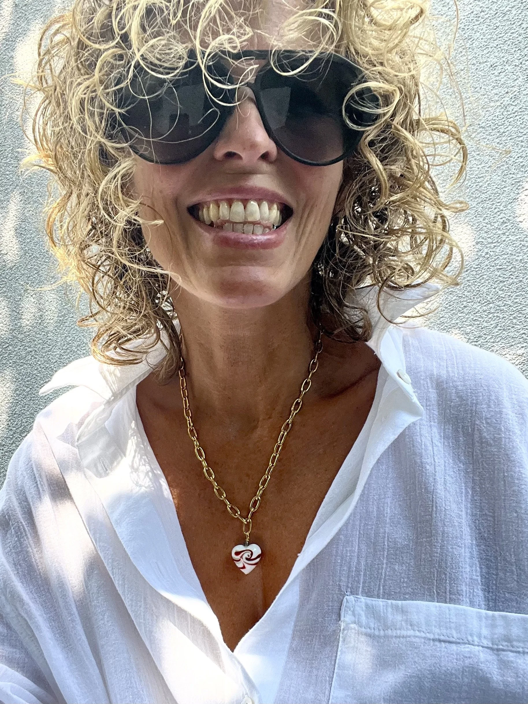 Frau trägt die Gladys Big White Heart als elegante Vintage-Kette mit weißem Murano-Herz.