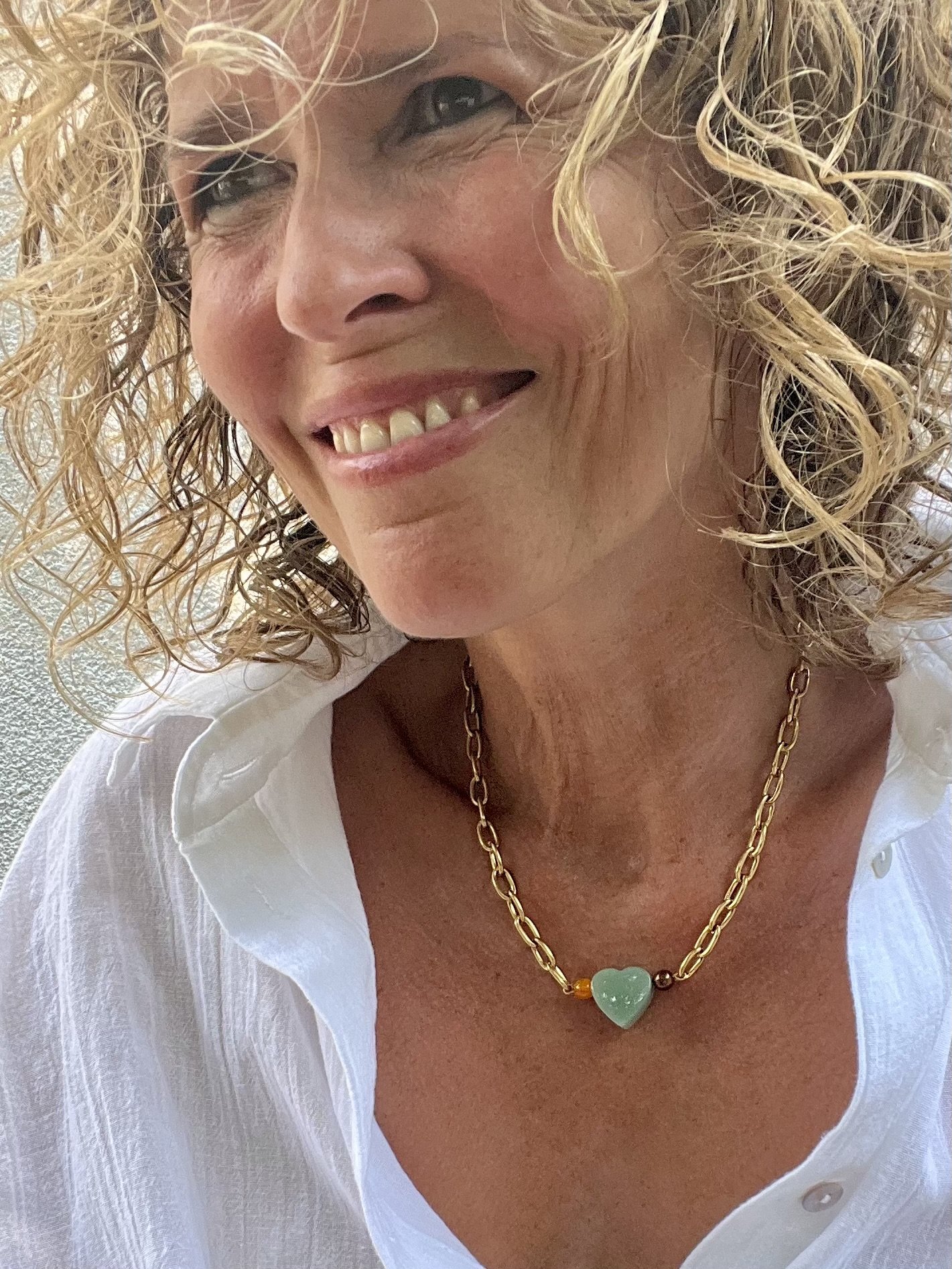 Frau trägt die Gladys Jadeherz als handgefertigte Vintage-Kette.