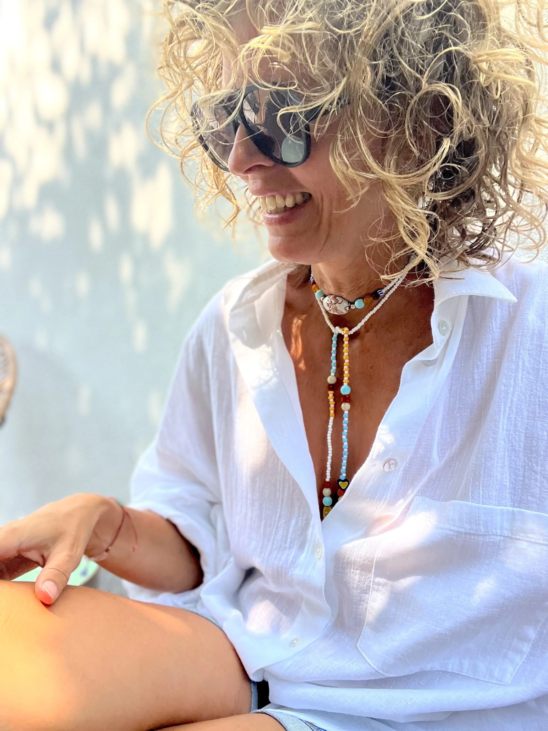 Handgefertigte Vintage-Perlenkette Bindi Belle mit Anhänger, getragen zu einer weißen Leinenbluse.