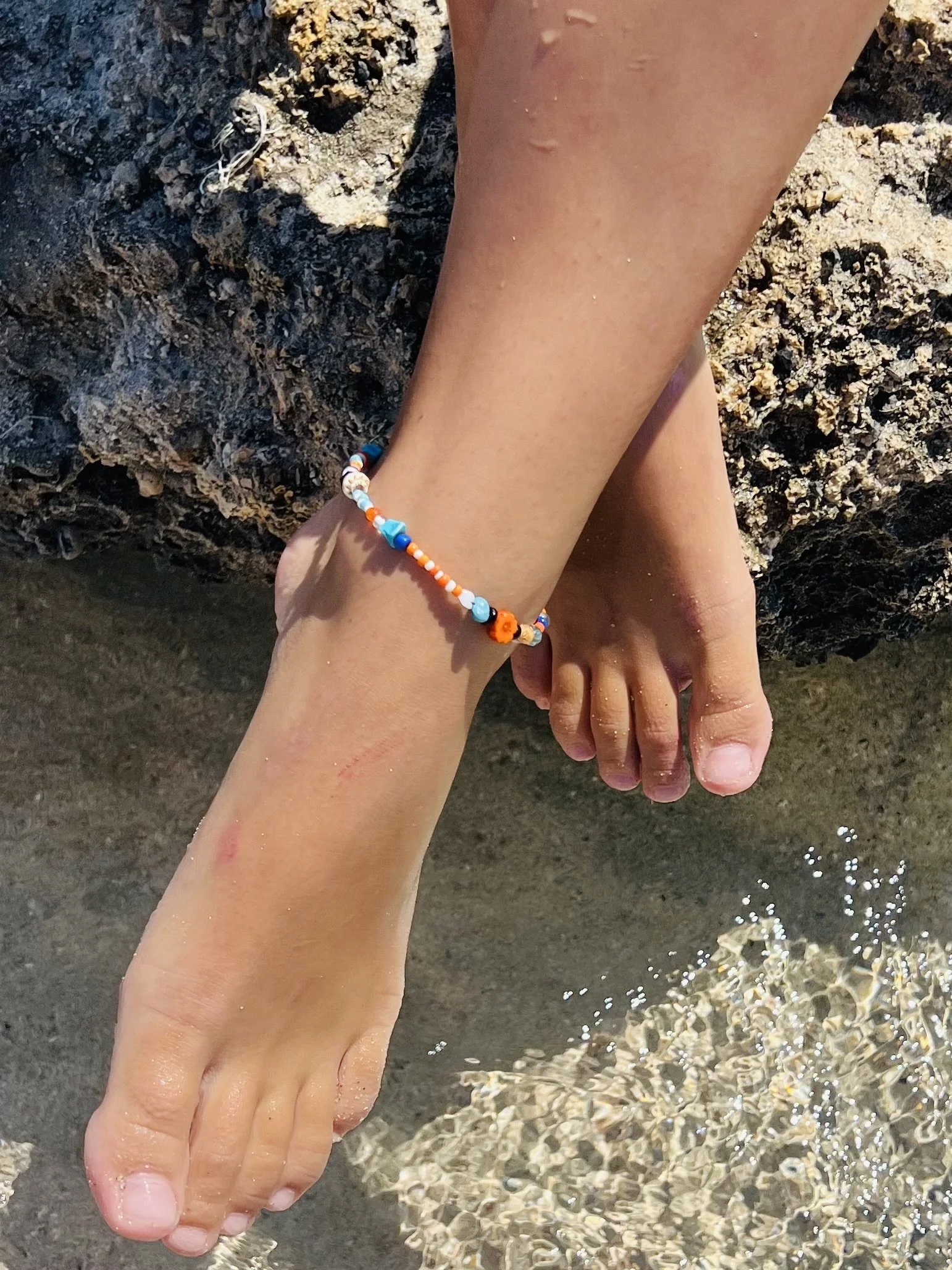 Fußkettchen Dimitra getragen auf Felsen am Meer
