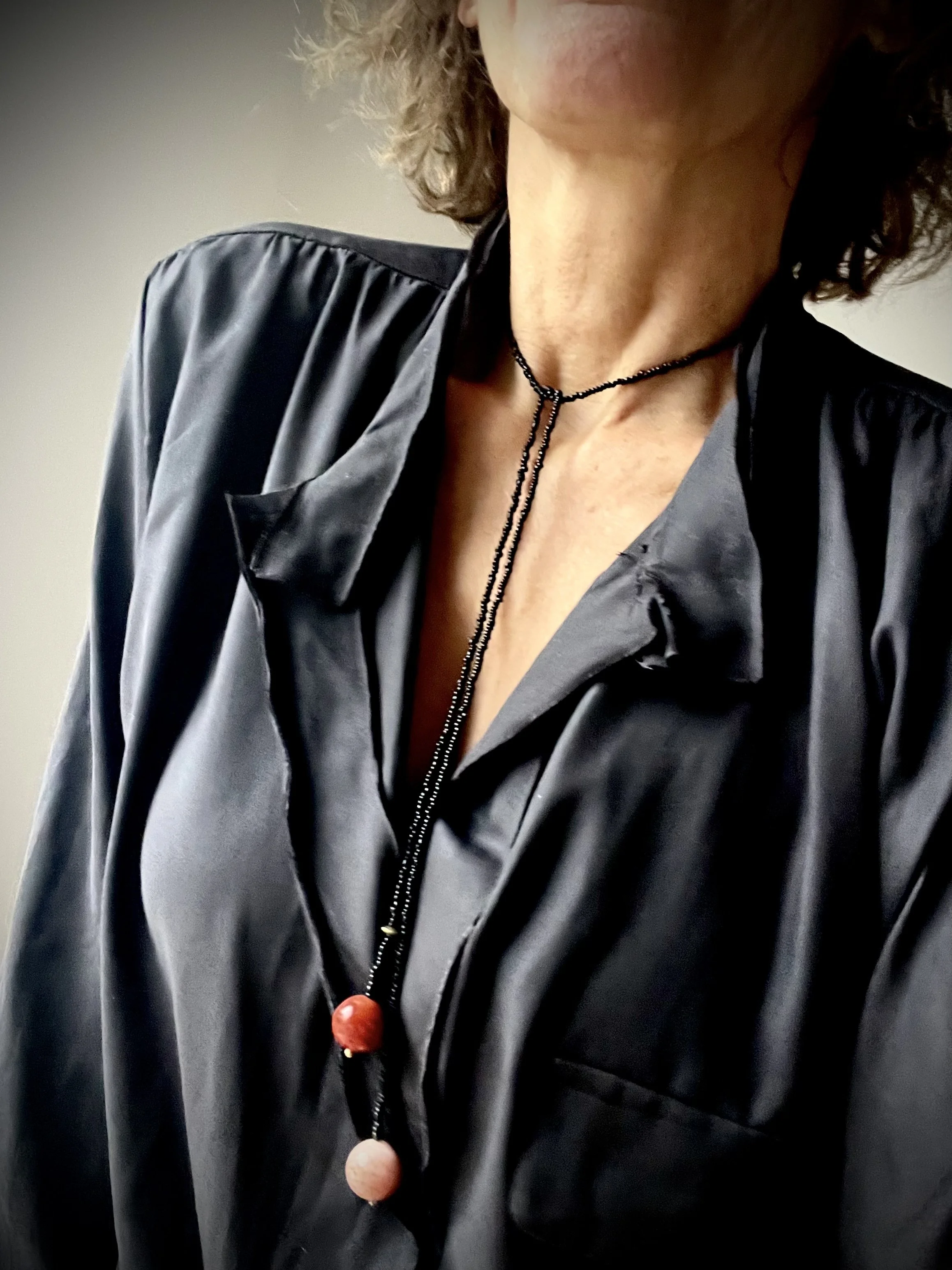 Bindi Belle Schwarz–Koralle in langer Tragevariante zu schwarzem Oberteil getragen
