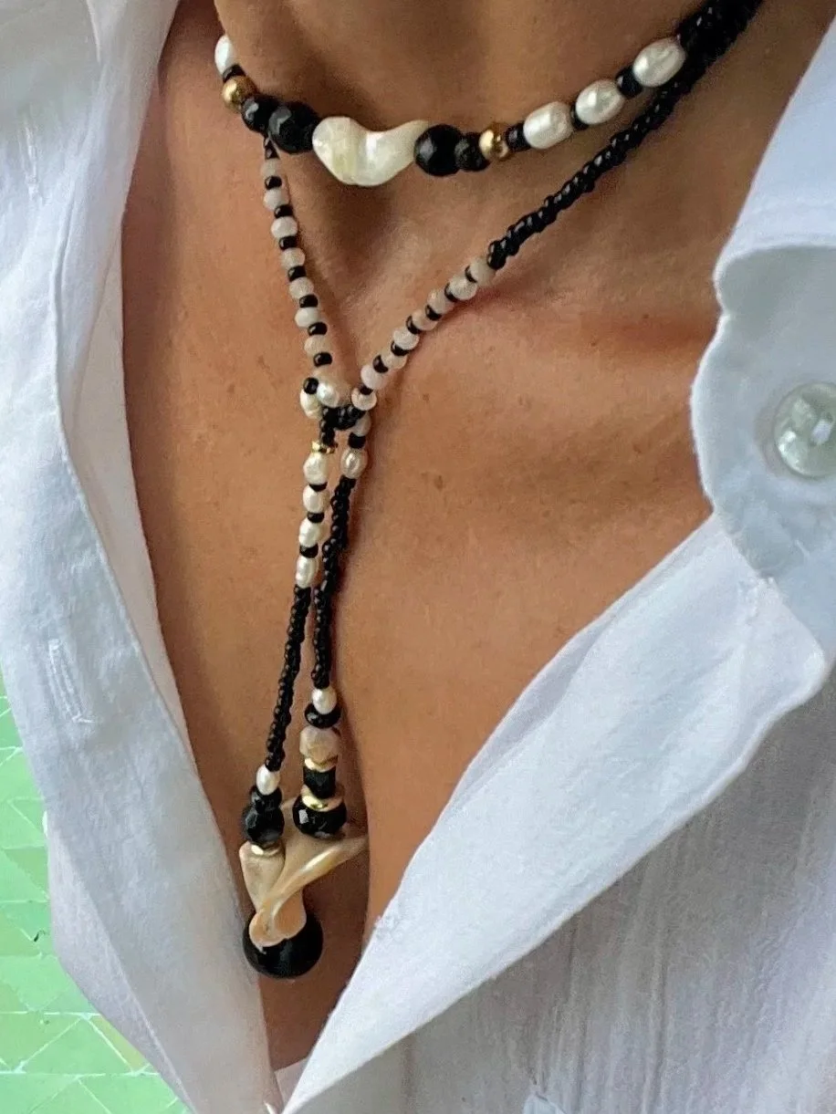 Detailaufnahme der Bindi Belle schwarz-beige-Muschel mit Muschel-Anhänger und Vintage-Perlen.