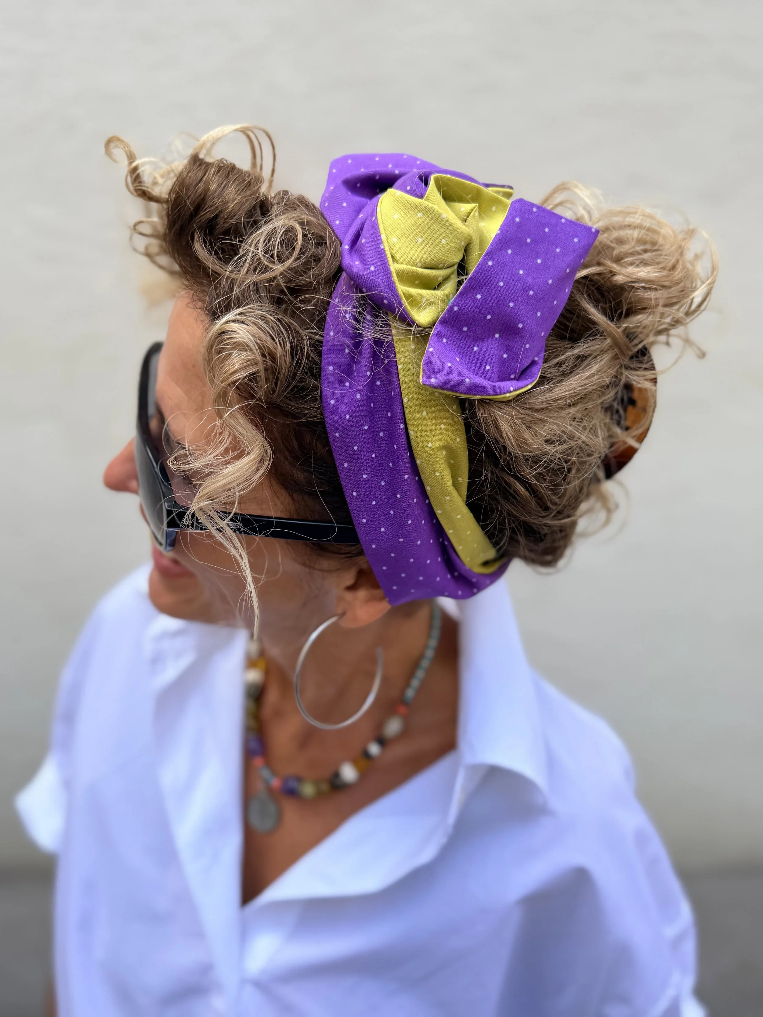 Mitzi - lila-senfgelbes Upcycling-Haarband aus einem alten Dirndl mit Draht, als große Masche im lockigen Haar getragen