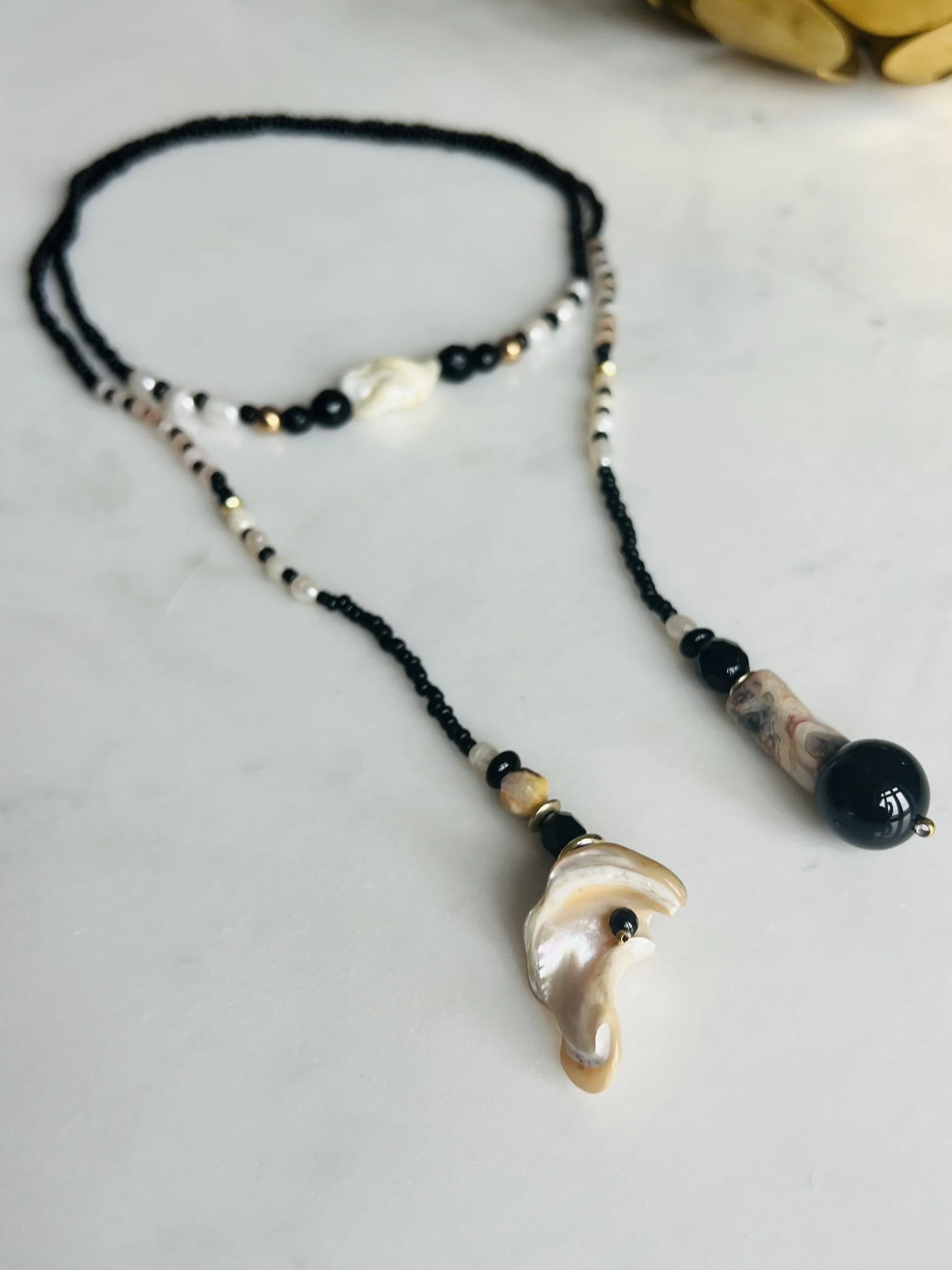Produktfoto der Bindi Belle schwarz-beige-Muschel – handgefertigte Upcycling-Kette mit echten Perlen, Karneolen, Onyx, Muscheln und Vintage-Perlen.