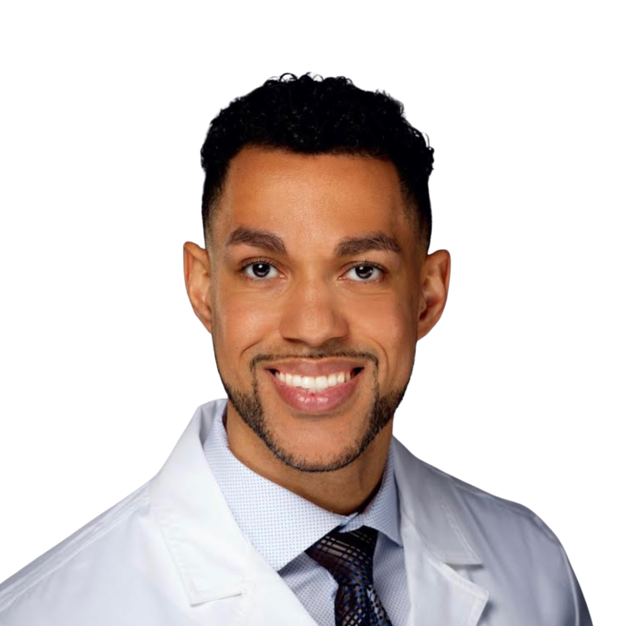 Portrait of a smiling man with dark curly hair, dressed in a white medical coat with the name 'Wallace Nozile, MD Dermatology' embroidered on it, wearing a patterned tie, against a dark grey background.
